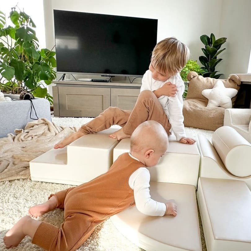 confident toddler building a grand beige foam block castle