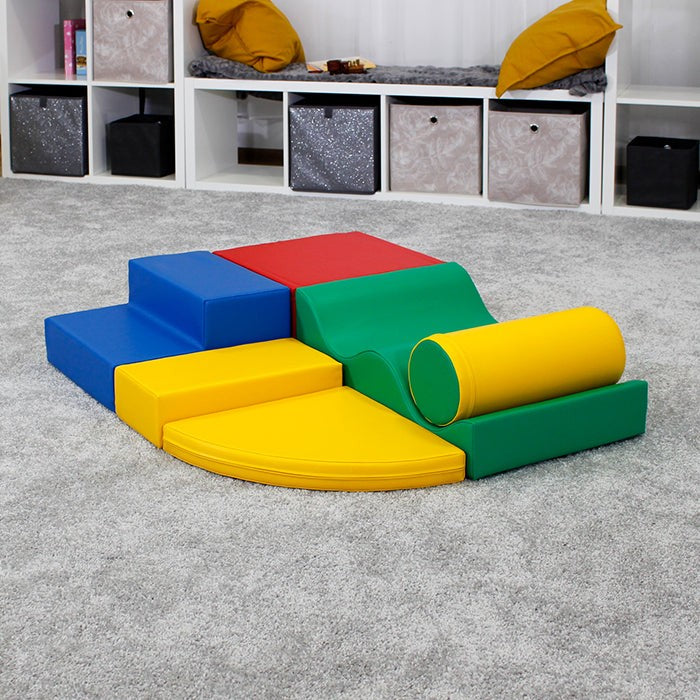 a child's small hands building a vibrant iglu soft foam block tower on a wooden floor