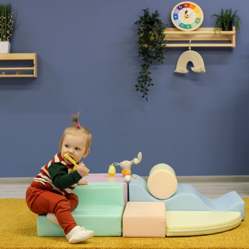 toddler building a soft pastel igloo fort with light pastel foam blocks