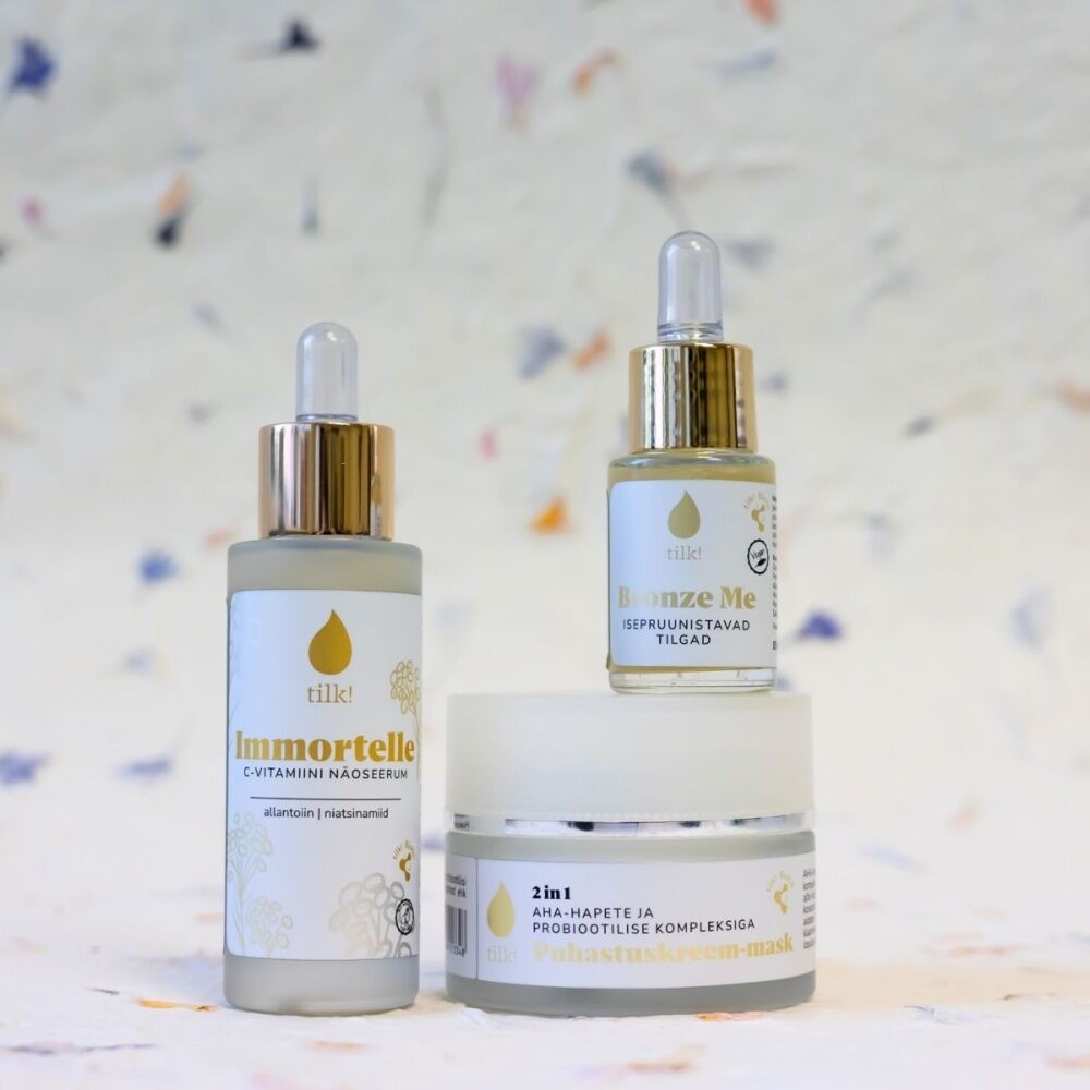 close-up of a woman gently applying immortelle serum for a soft, radiant glow
