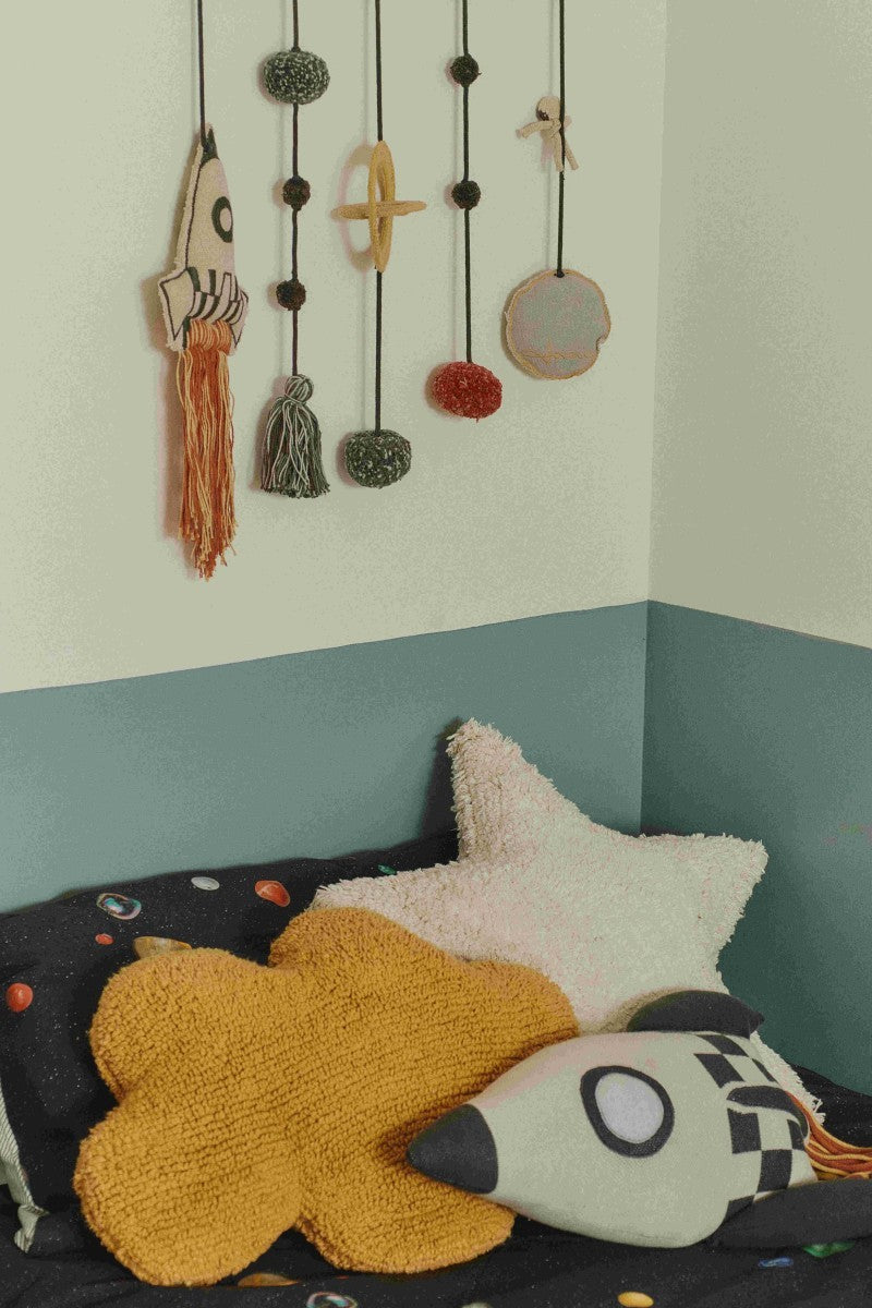 This pillow is made of knit fabric in natural and dark gray colors with blue details and colorful long fringes that bring to mind fire explosions. Made of high-quality cotton, it offers a cozy feeling, perfect for cuddling up or adding a cosmic touch to any room. Filled with 100% polyester, it is easy to wash and dry in the washing machine. An updated classic design by Lorena Canals, now with improved aesthetics and materials. by Lorena Canals at www.brixbailey.com