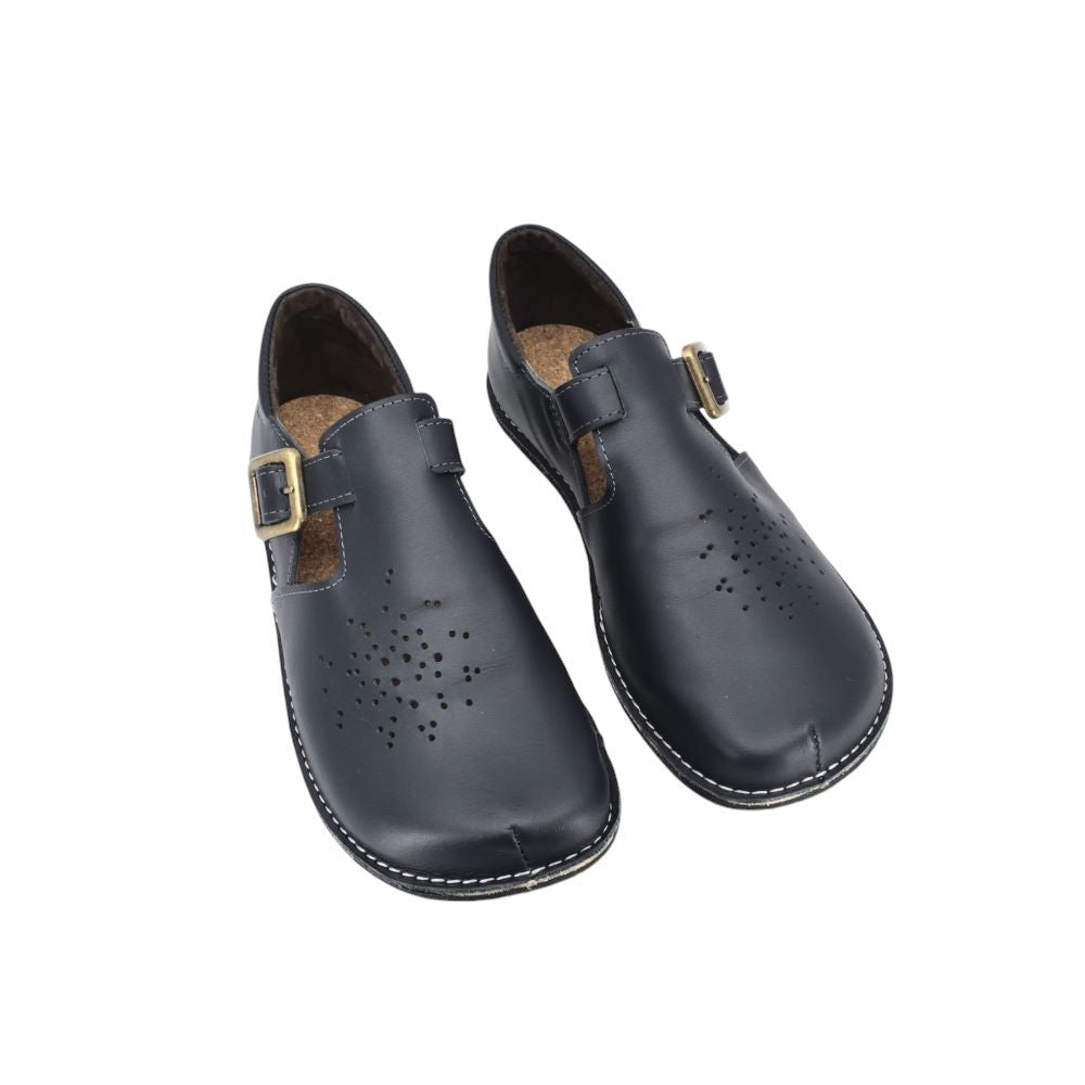 bold dark blue kuuda shoes on a model showcasing the adjustable leather buckle straps and wide toe box