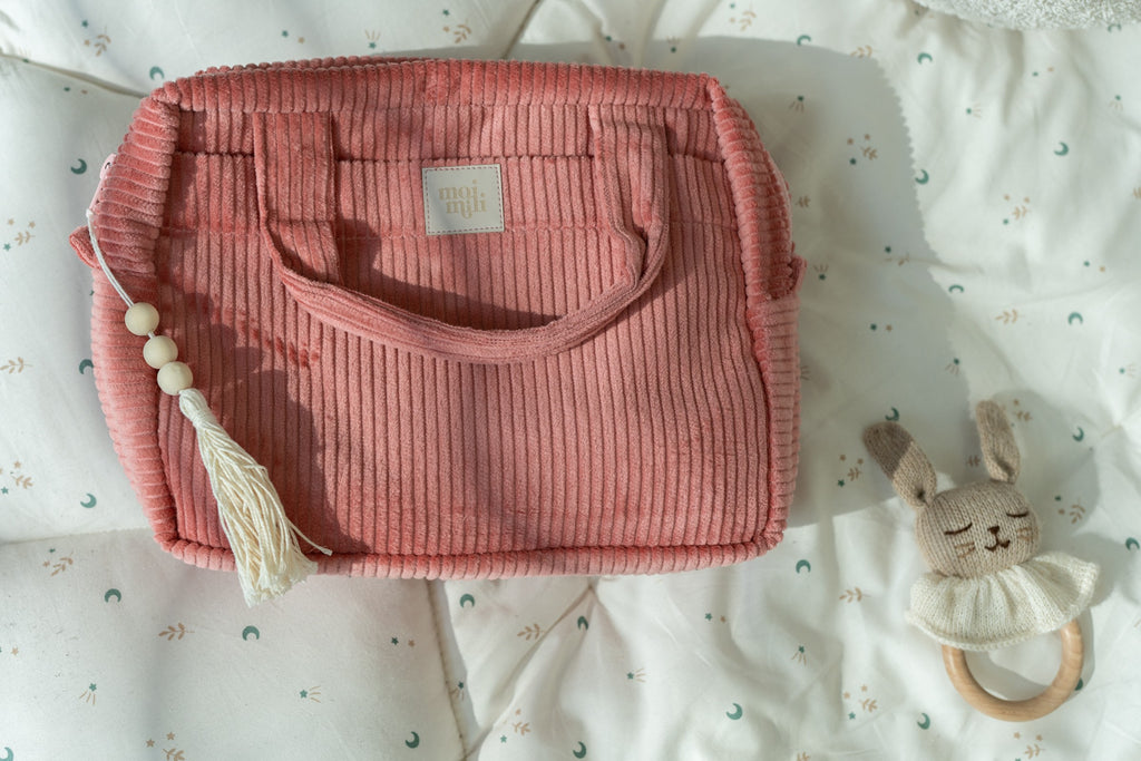 two chic coral cotton makeup bags on a rustic wooden table in warm morning light