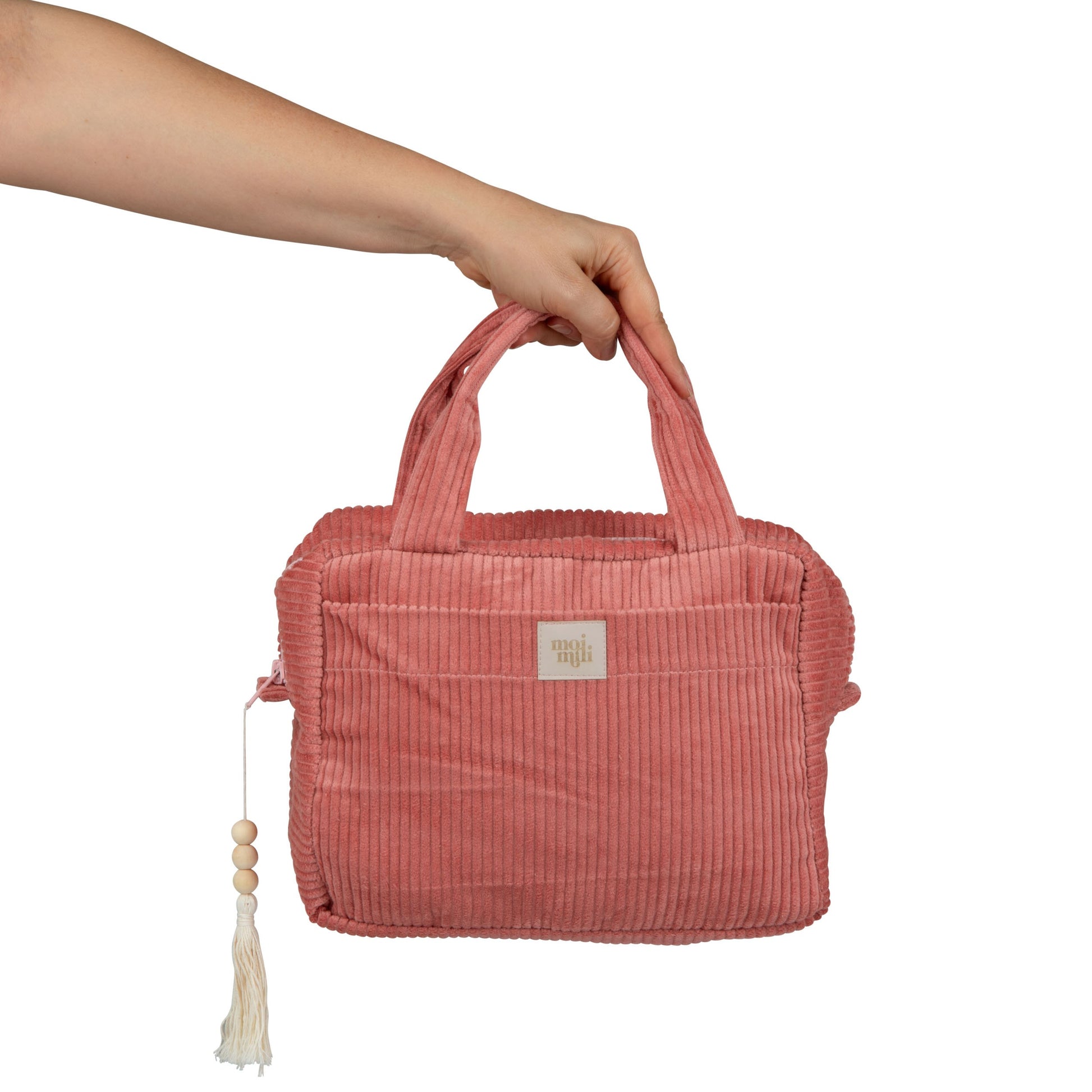 bold coral makeup bag open on a sunlit surface revealing its spacious waterproof interior