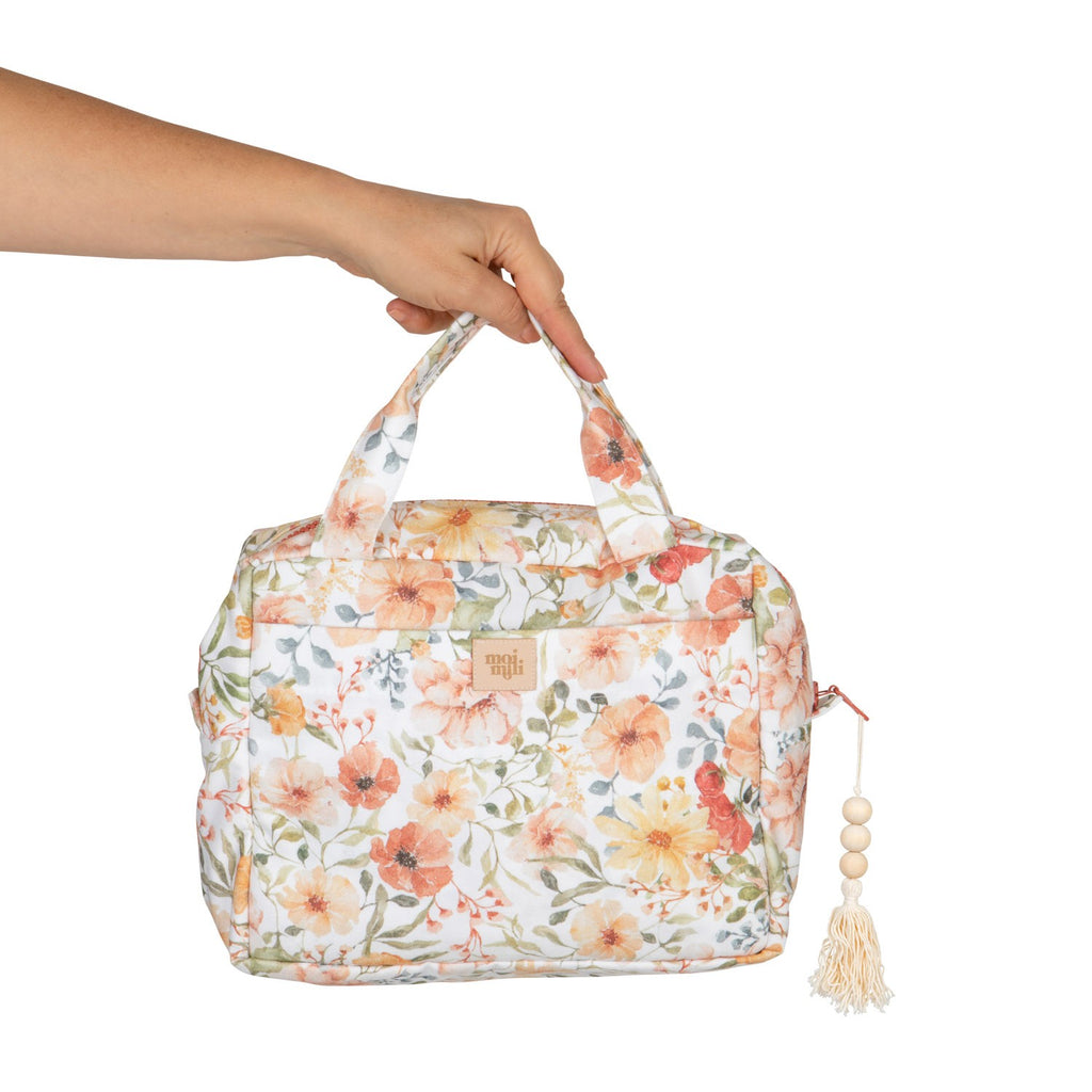 bold floral cotton makeup bag open on a travel vanity, showcasing its spacious interior and pockets