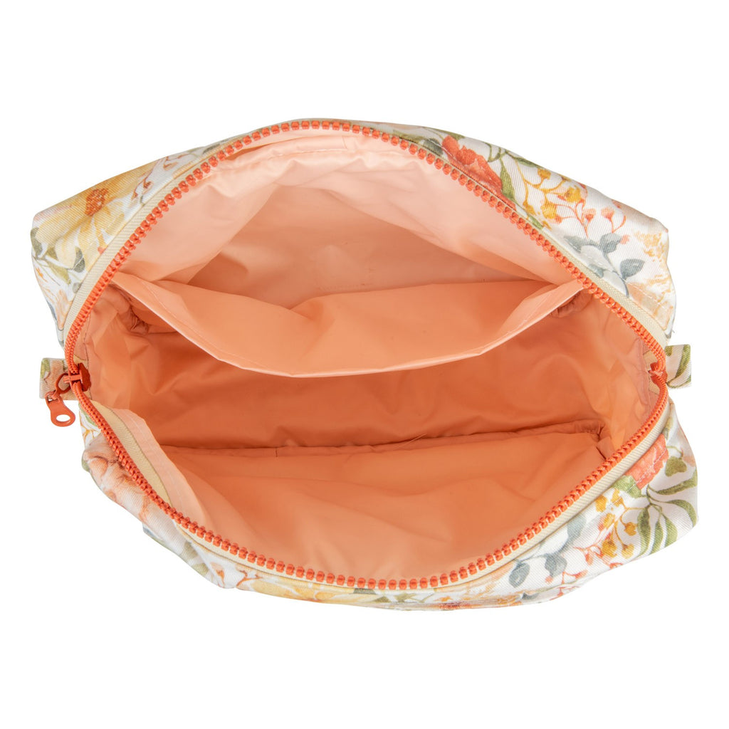 softly lit small cotton makeup bag with floral print resting on a cozy surface
