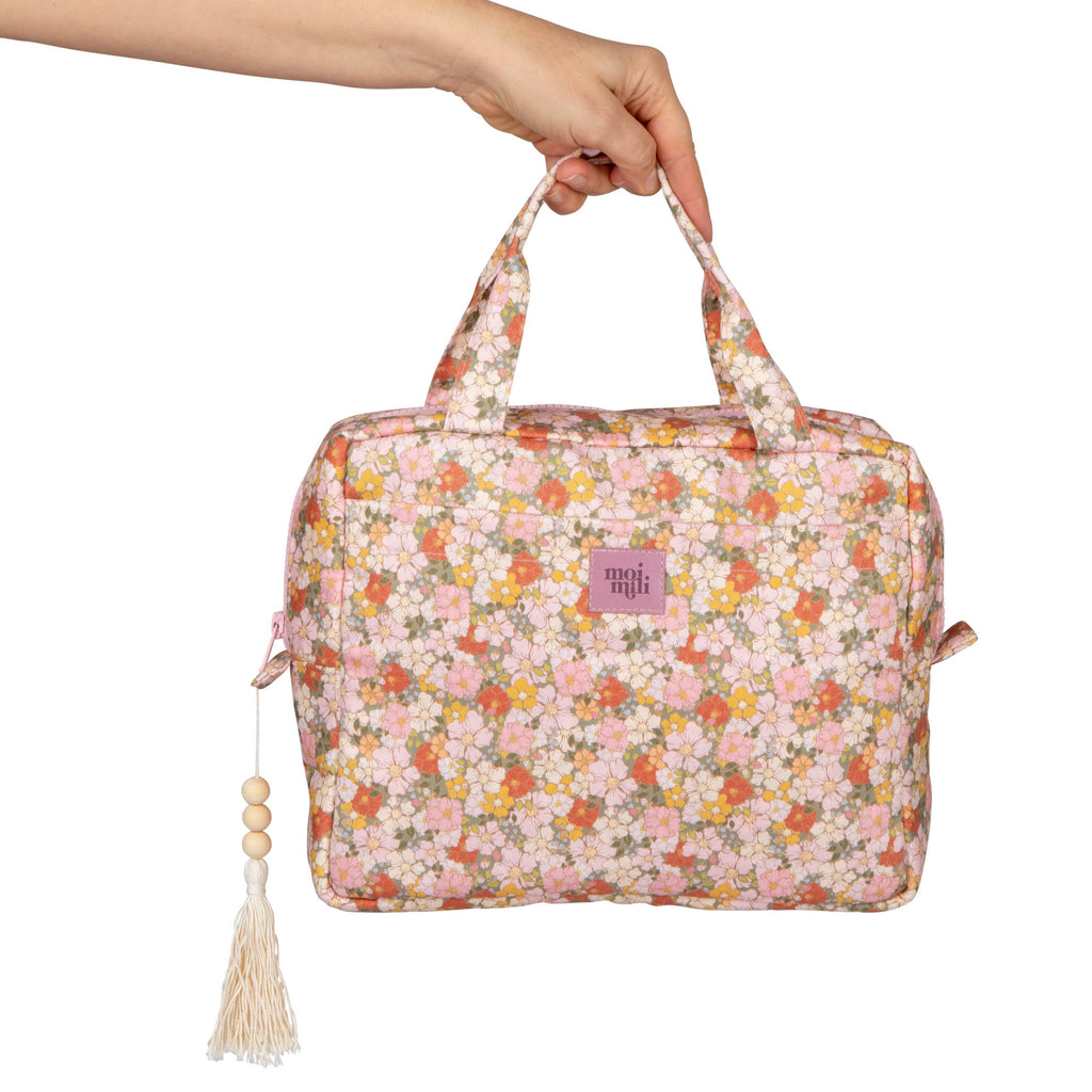 confident green garden makeup bag set laid open on a rustic wooden table