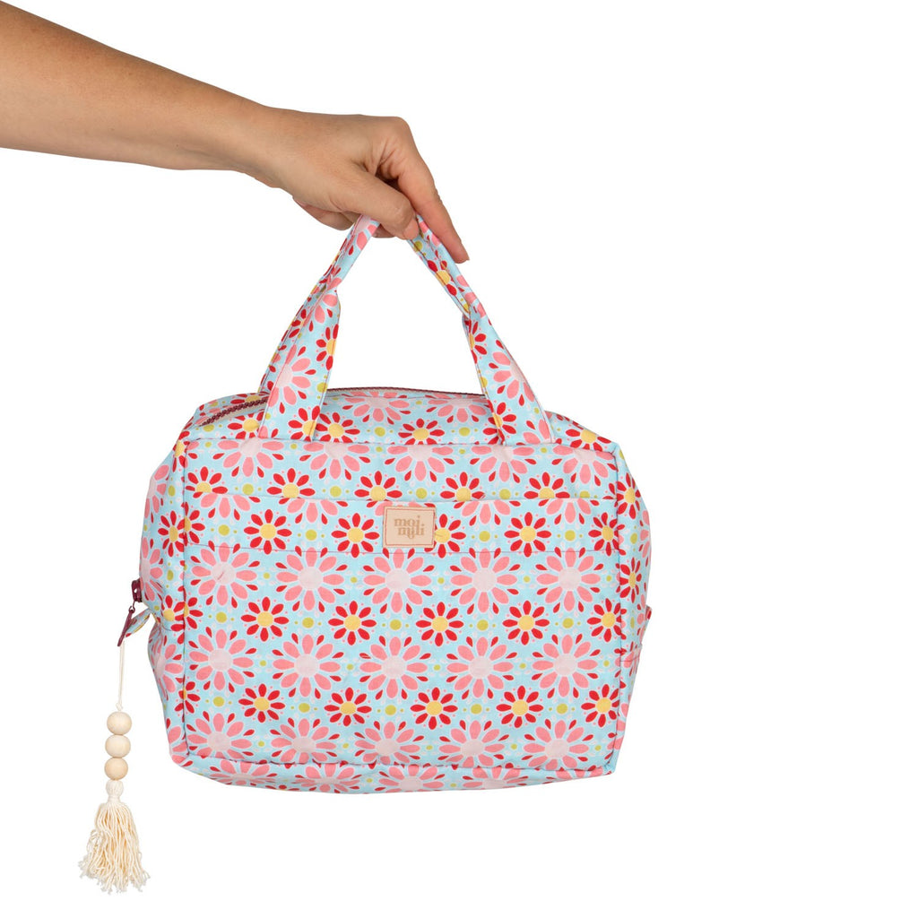 bold red floral makeup bag set open on a rustic table showcasing its spacious waterproof interior