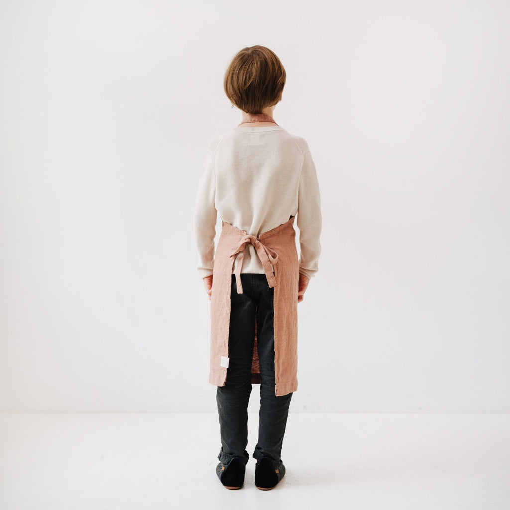 elegant cafe creme linen kids apron on a rustic wood table, showcasing its artisan craftsmanship and refined texture