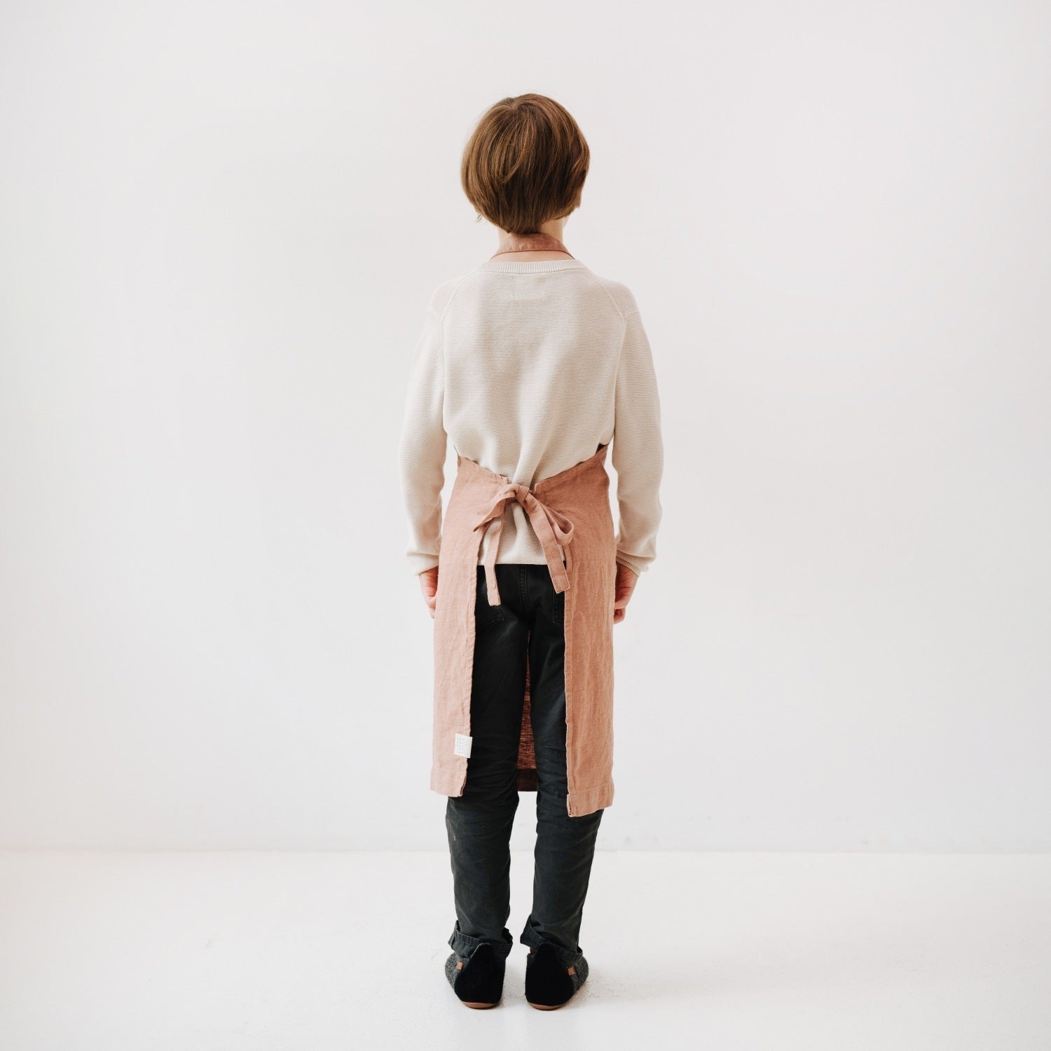 elegant cafe creme linen kids apron on a rustic wood table, showcasing its artisan craftsmanship and refined texture