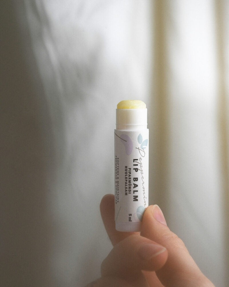 a small tin of peppermint lip balm nestled on soft craft leather, glowing with a warm, comforting light