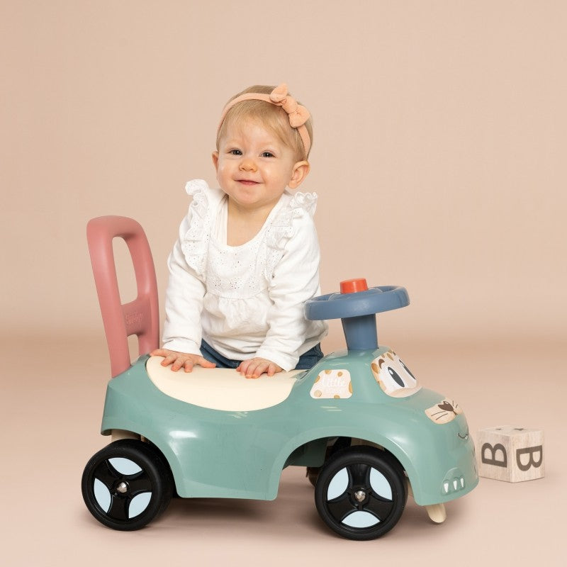 playful pastel ride-on pusher with horn, toddler giggling as they push the walker-car hybrid on sunny grass