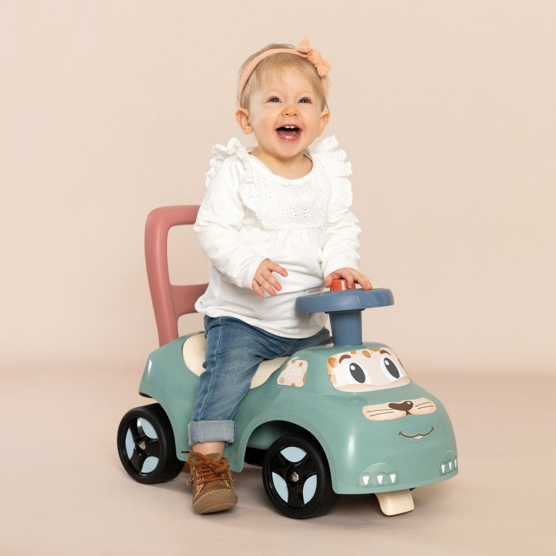 bold pastel ride-on pusher with horn for toddlers - sturdy plastic walker in sunny outdoor setting