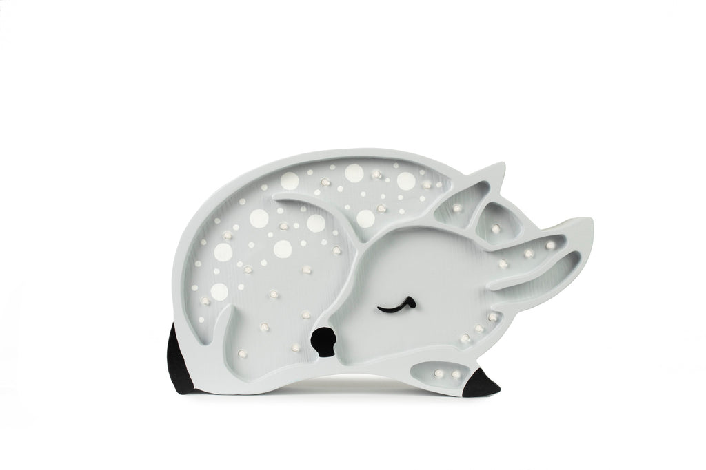 handcrafted pine deer lamp casting a soft glow on a nursery shelf