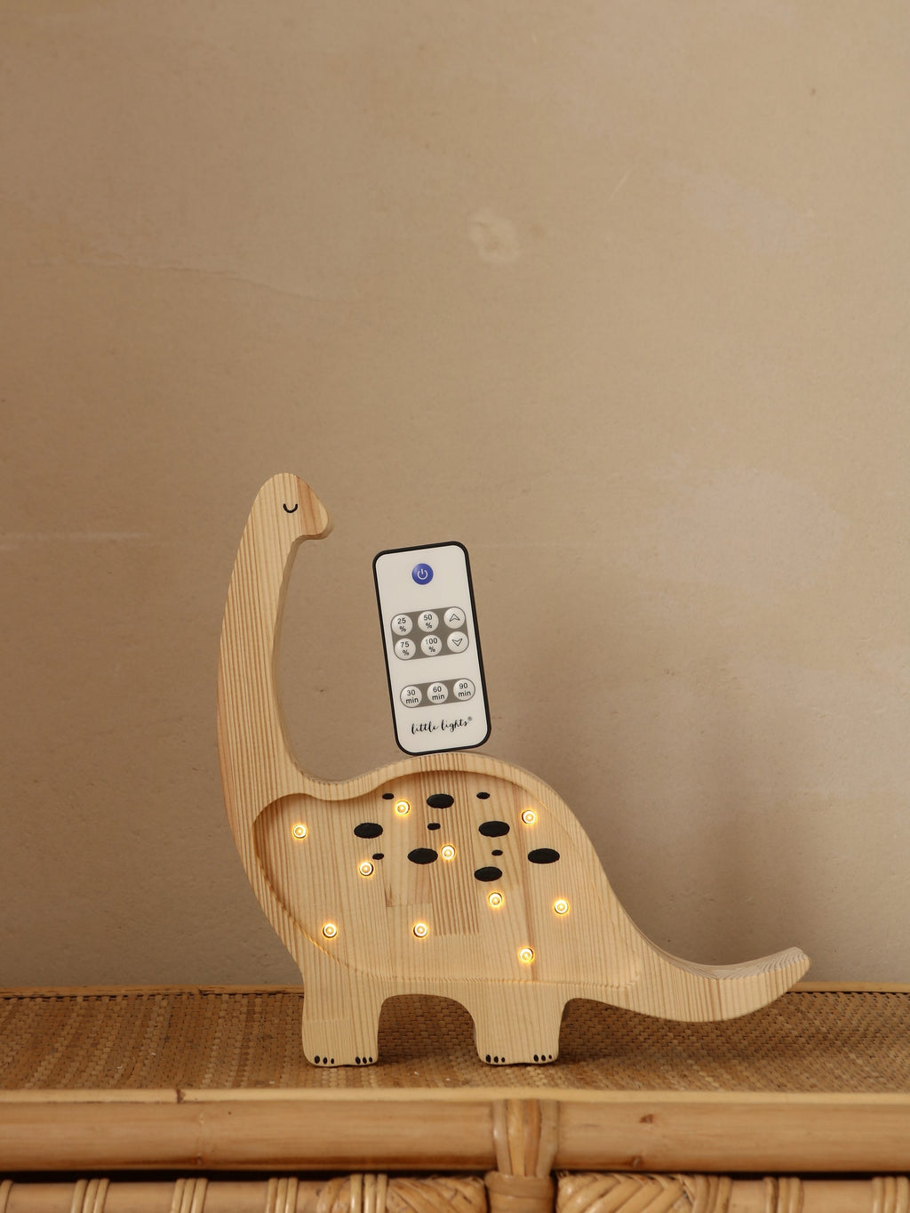a close-up detail of the artisan-crafted pinewood dinosaur lamp glowing warmly on a bedside table