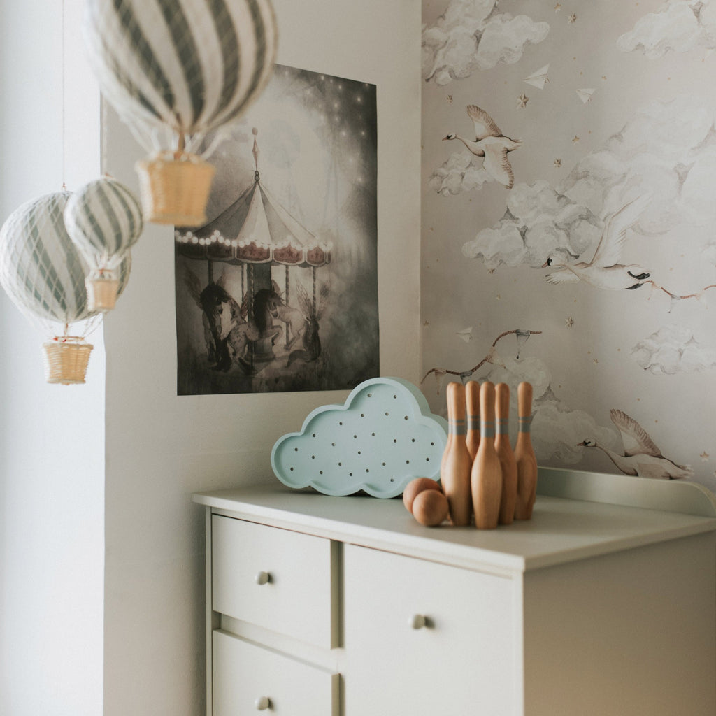 handmade pine wood cloud lamp casting a soft warm glow on a nursery shelf