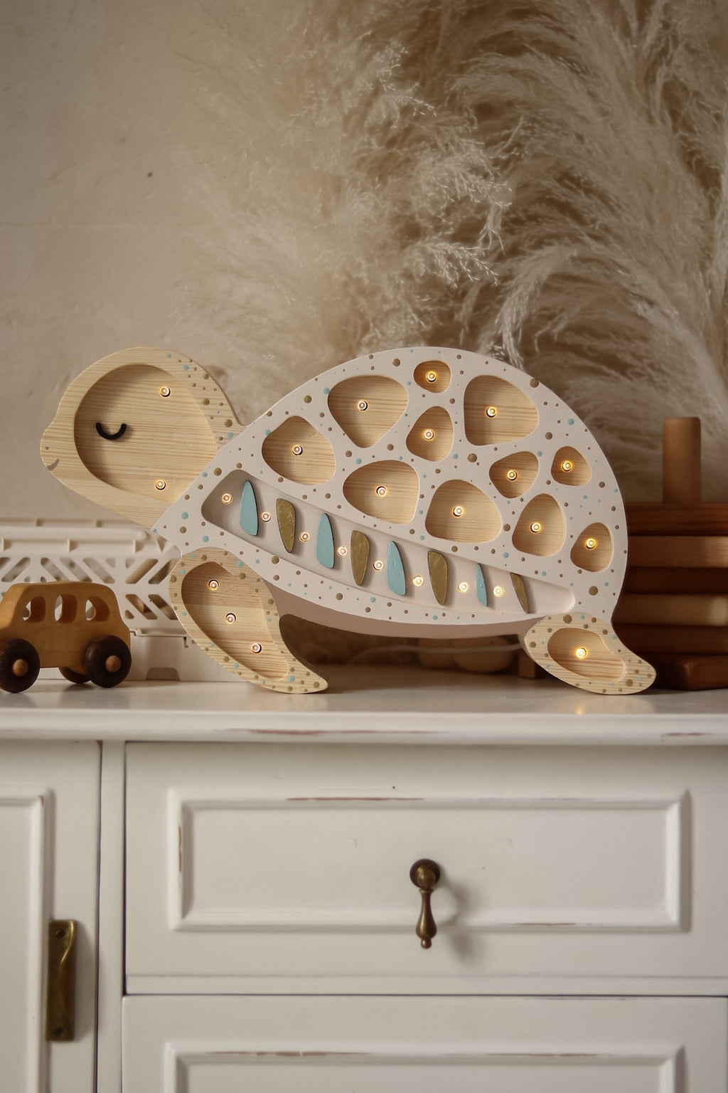 handmade pine wood turtle lamp casting a warm glow on a bedside table