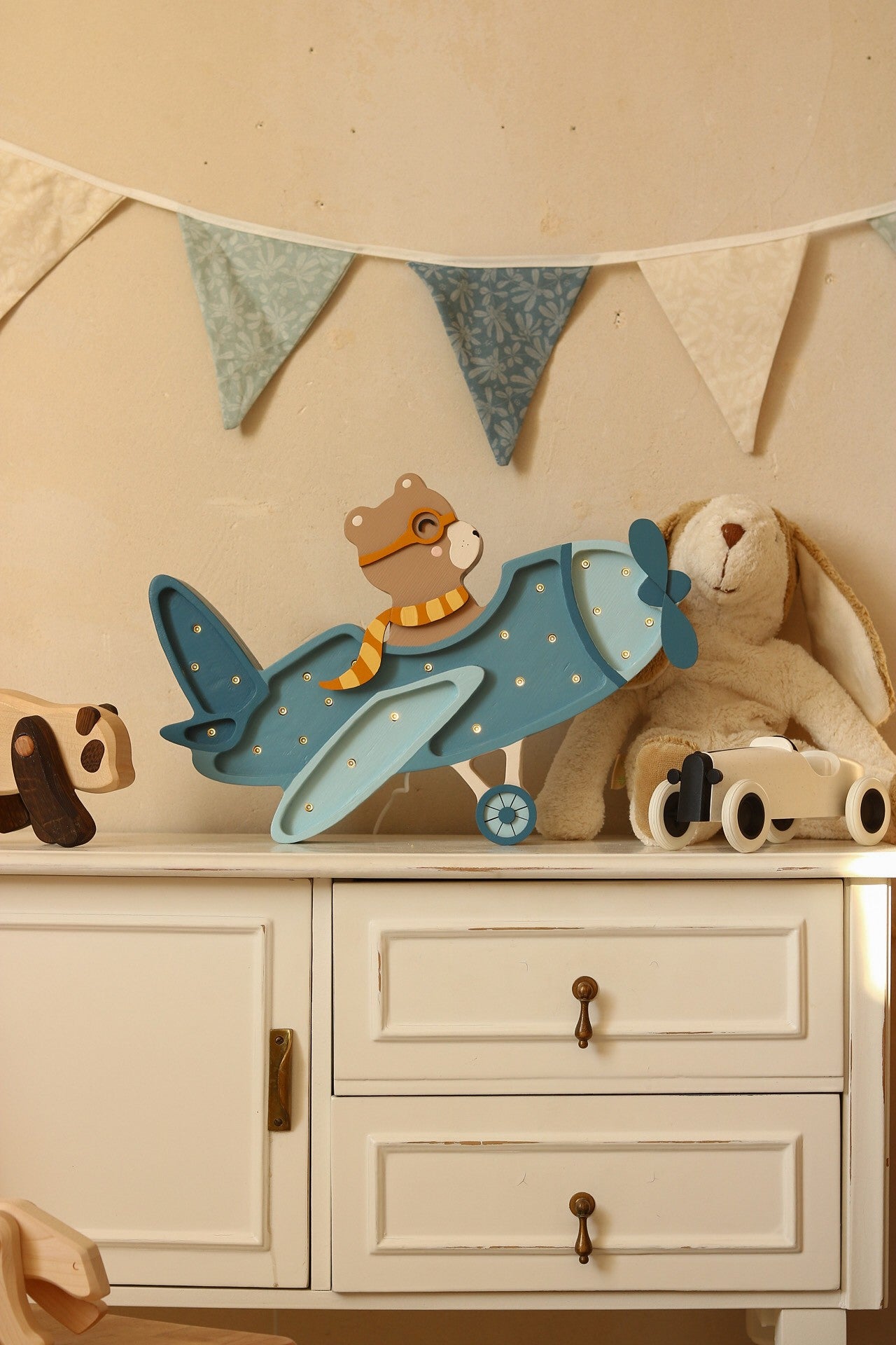 elegant vintage aircraft lamp in solid pinewood with warm led glow on a refined nursery shelf