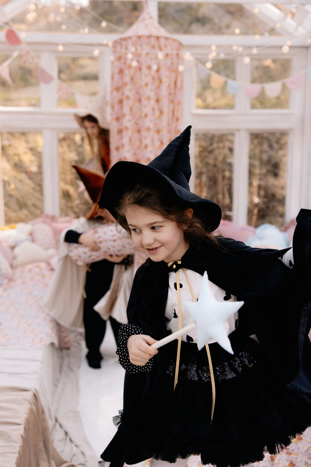 child in a black velour hooded cape casting a shadow in the moonlight
