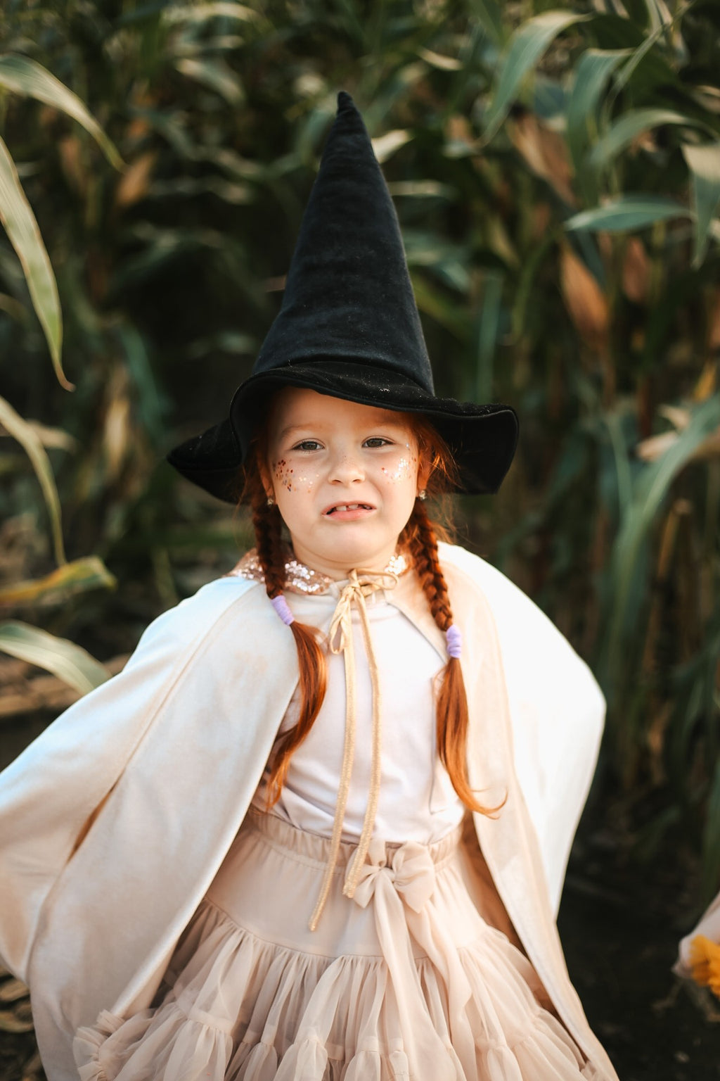 close-up of the snap fastening and laces on a cream velour magic cape for kids