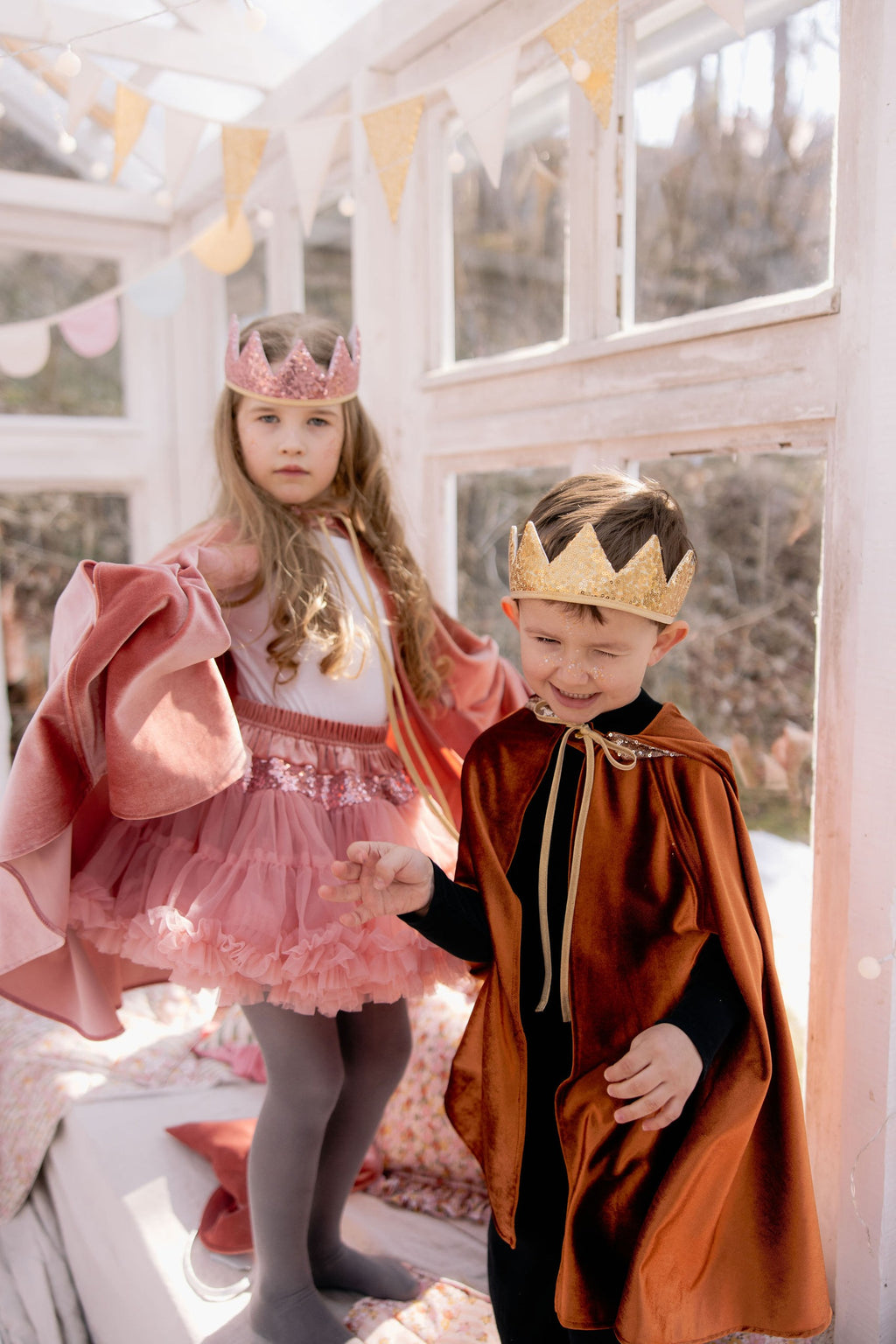 practical view of the ginger velour cape showing its snap fastening and hand holes for easy play
