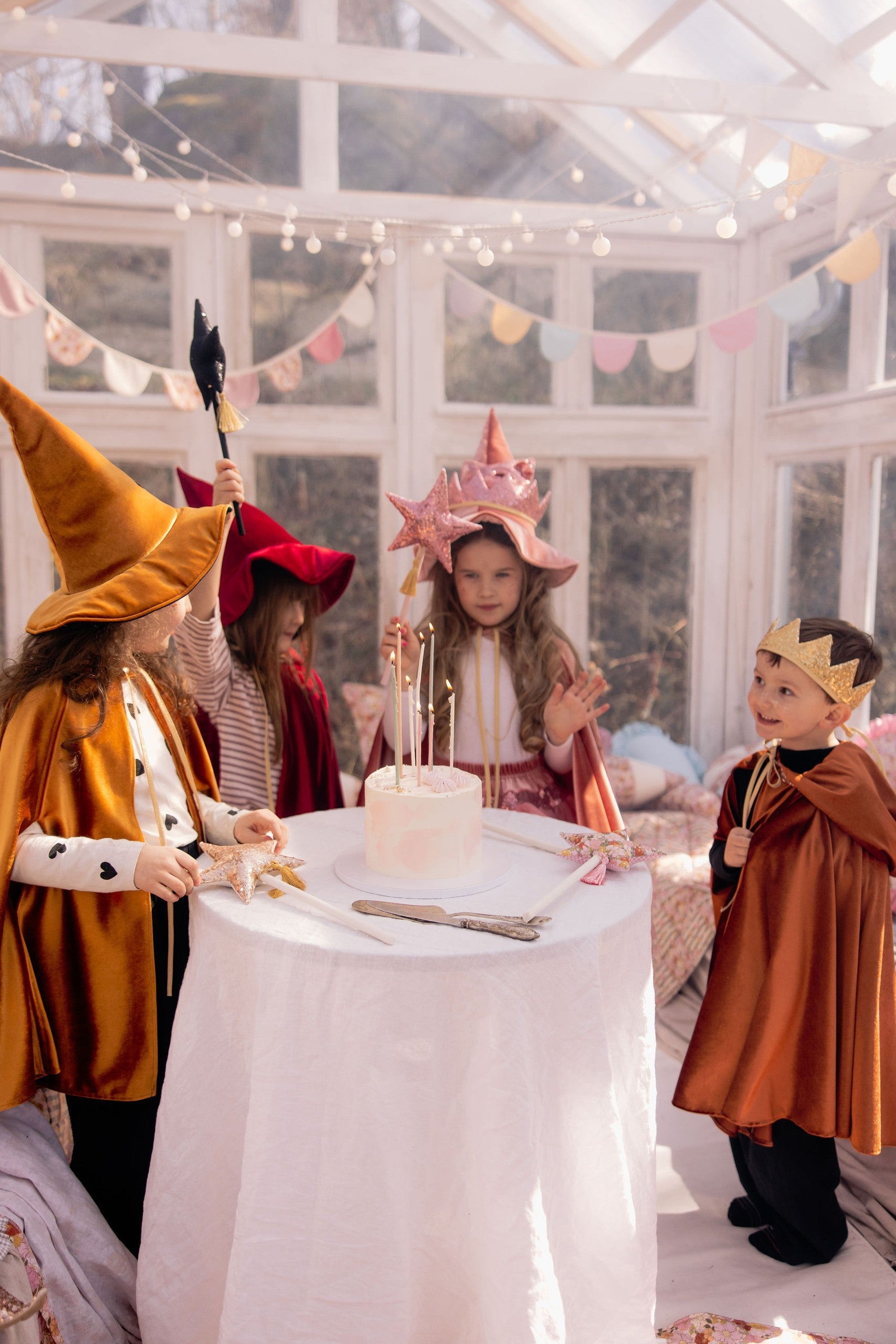 child in golden velour hooded cape twirling in a sunlit garden adventure