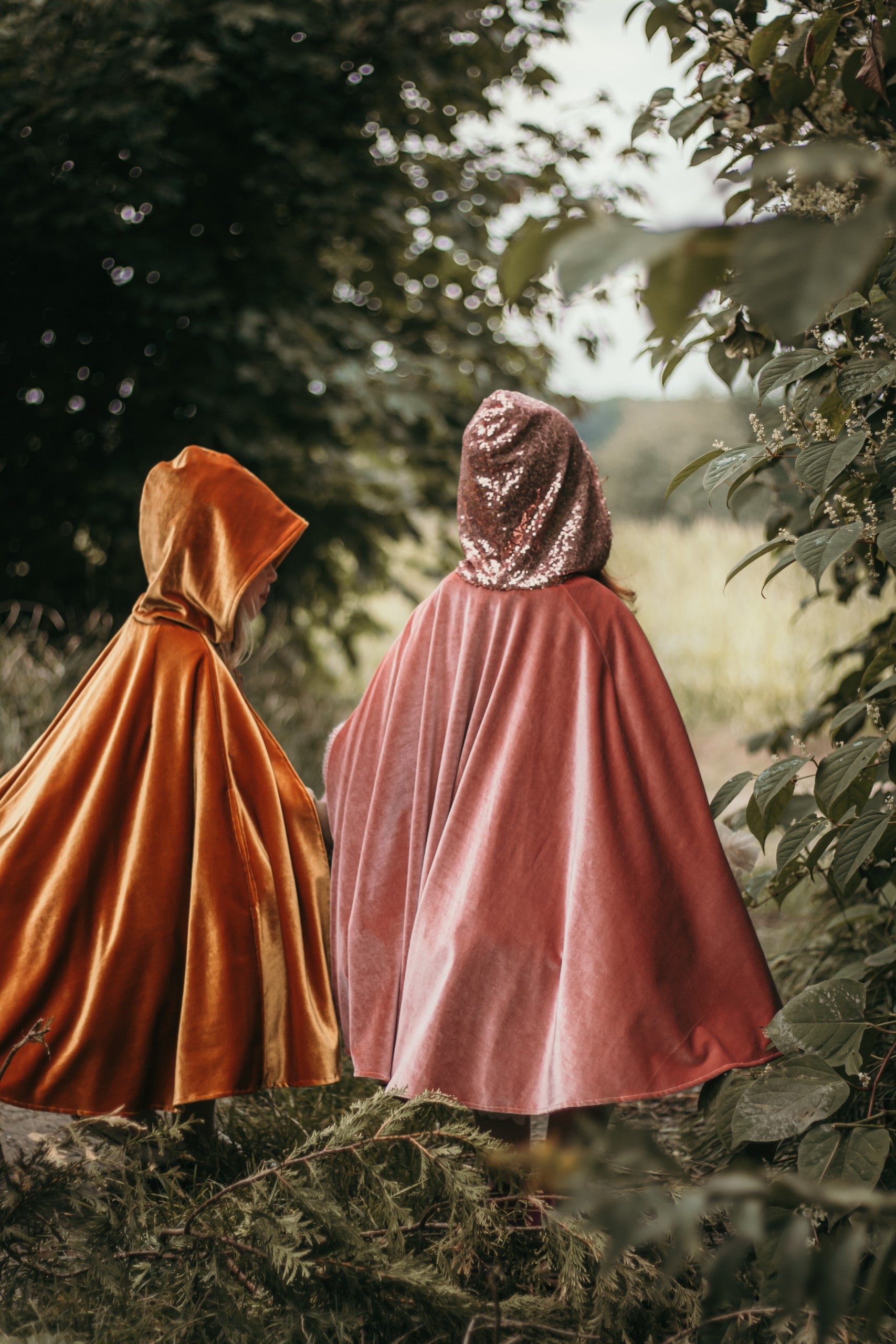 pink velour magic cape with deep hood and snap fastening, swirling in soft indoor light