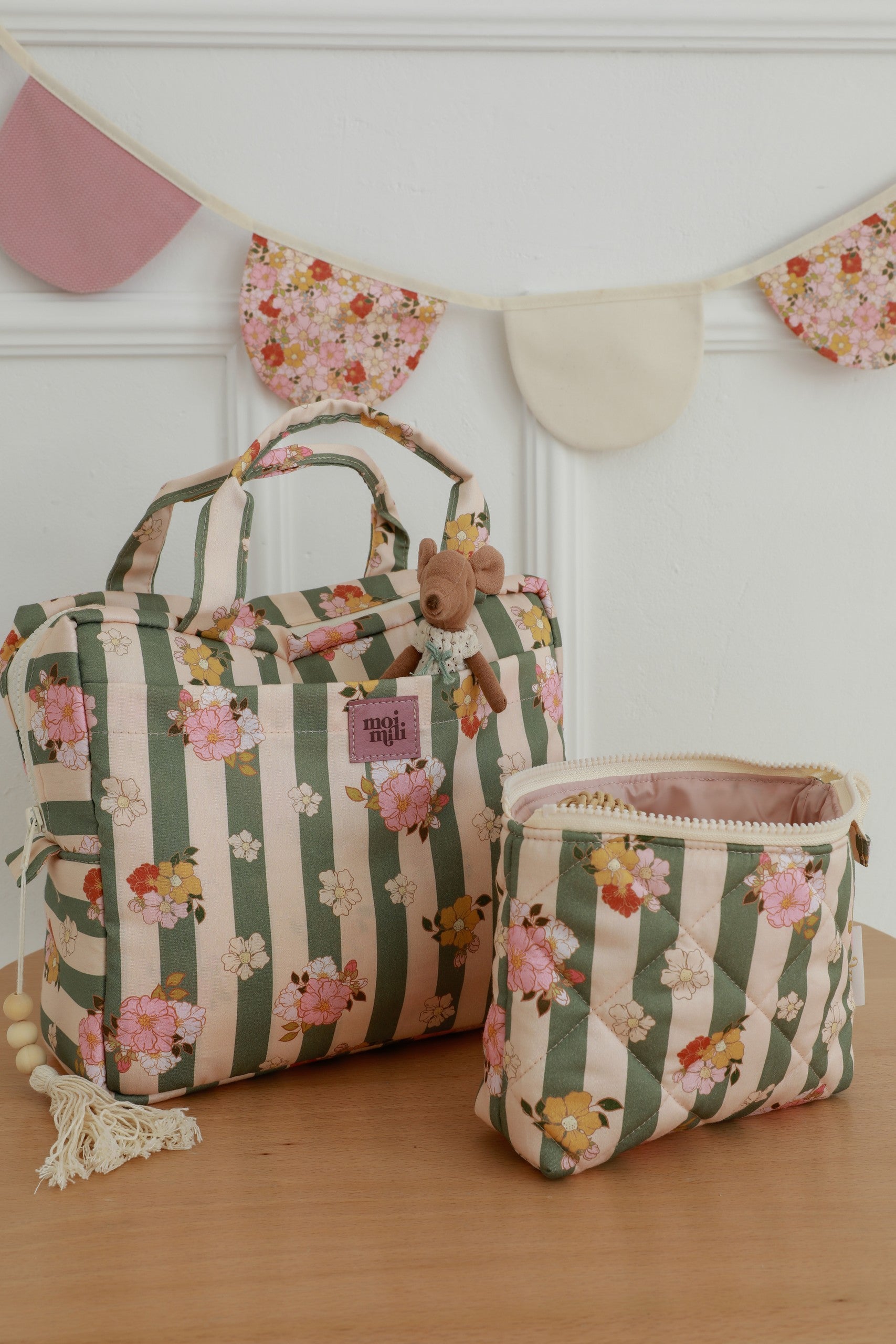 bold green striped makeup bag set of two on a dark background, showcasing its stylish cotton design