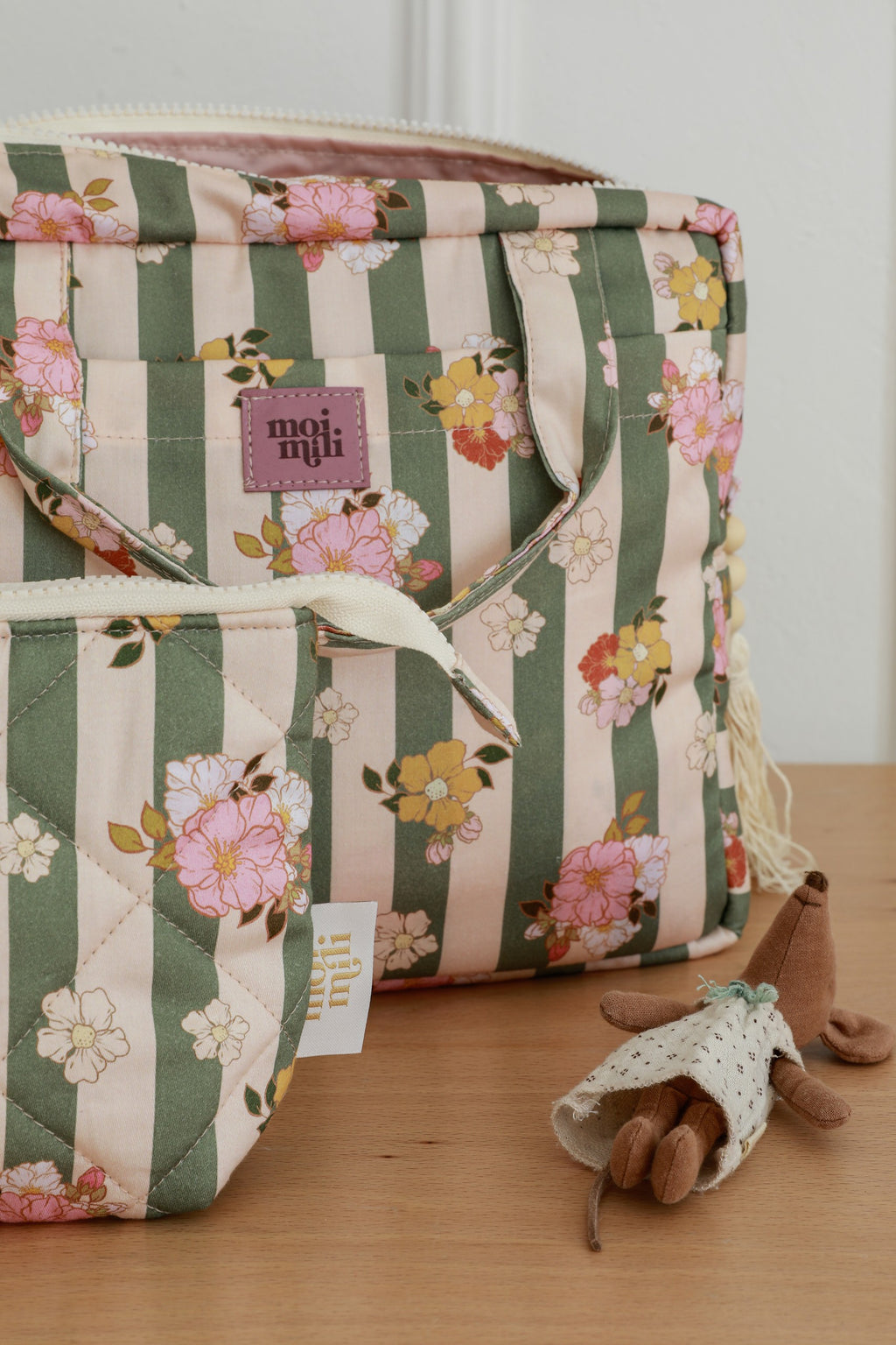 stylish green striped cotton makeup bag set of two laid flat on a rustic wooden table