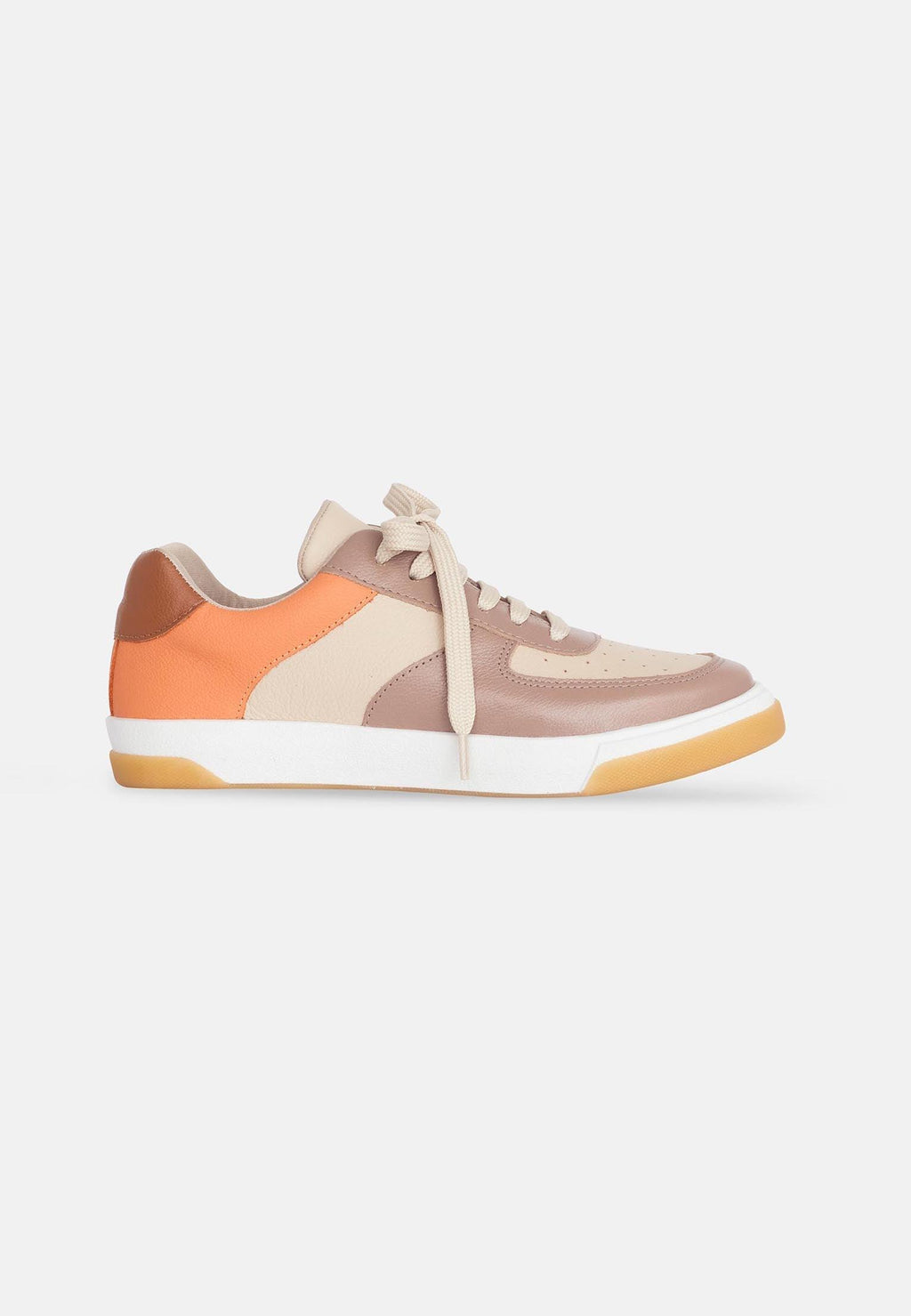 confident woman in beige andira leather sneakers on a city street
