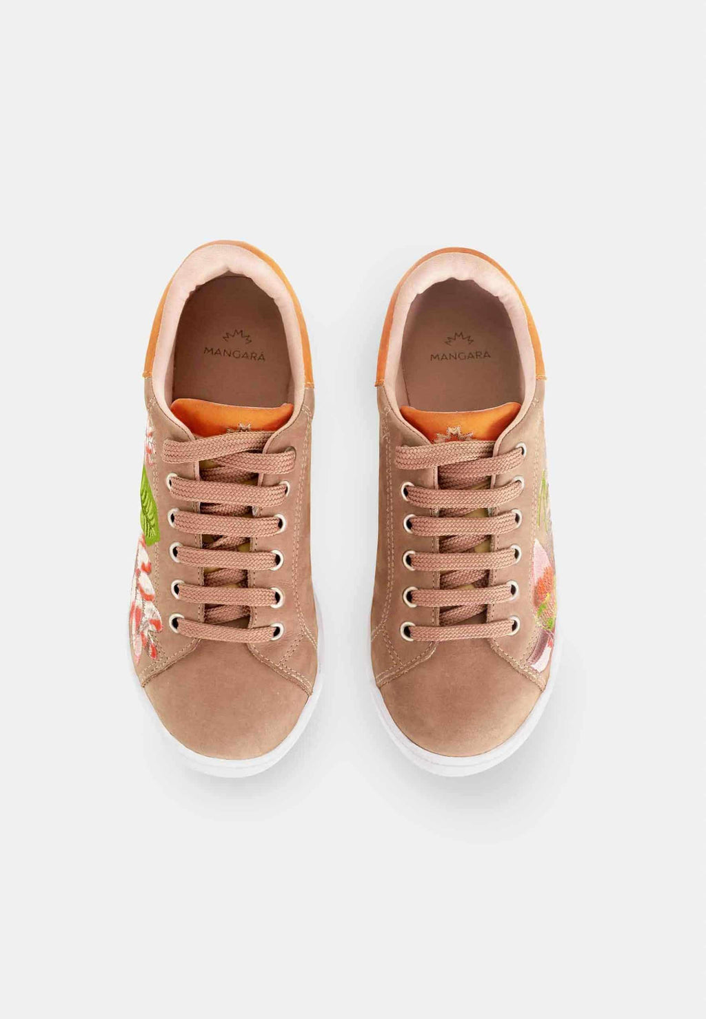 soft brown suede women's sneaker with intricate floral embroidery on a cozy background