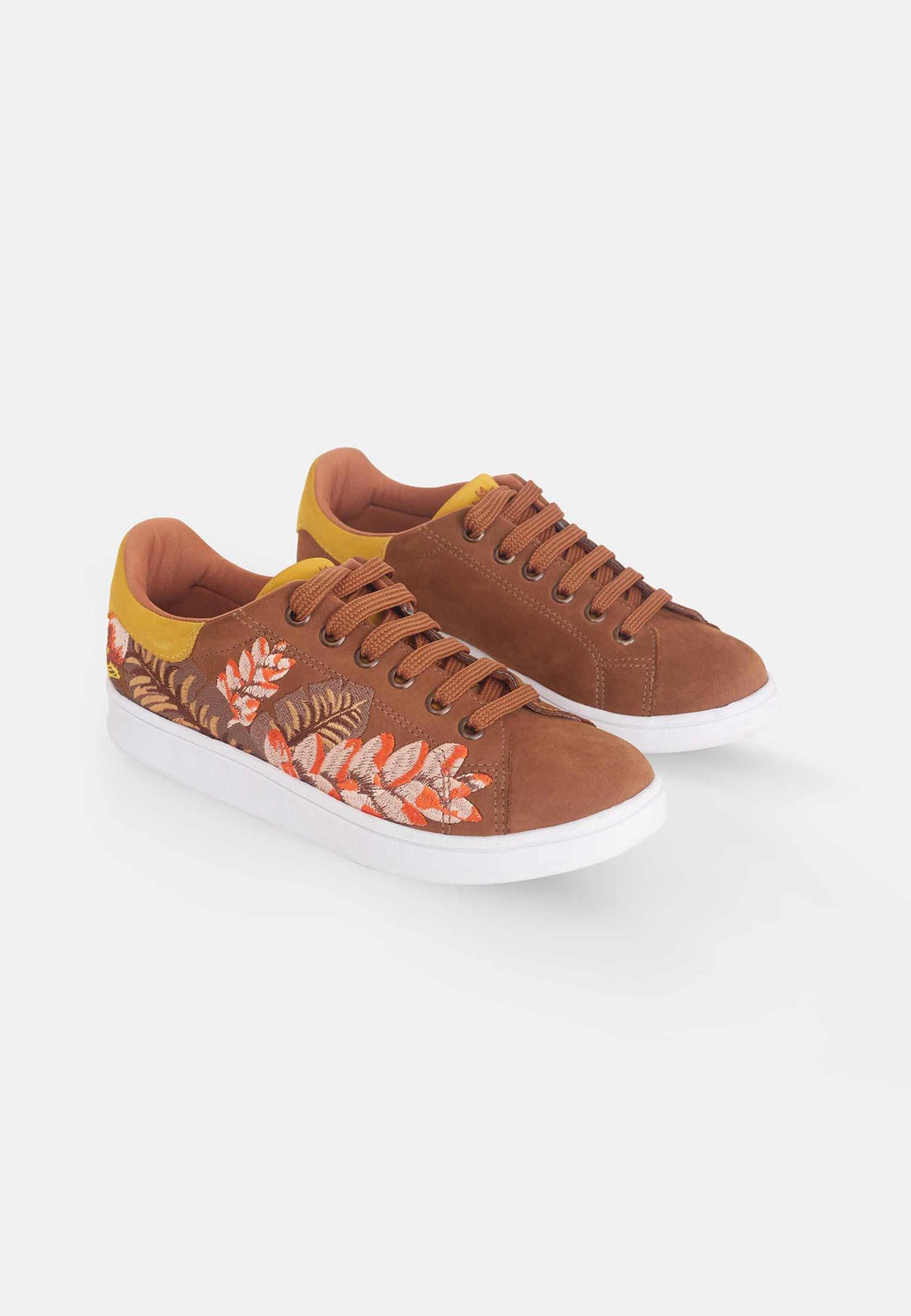 close-up detail of the floral embroidery on the soft brown suede sneakers