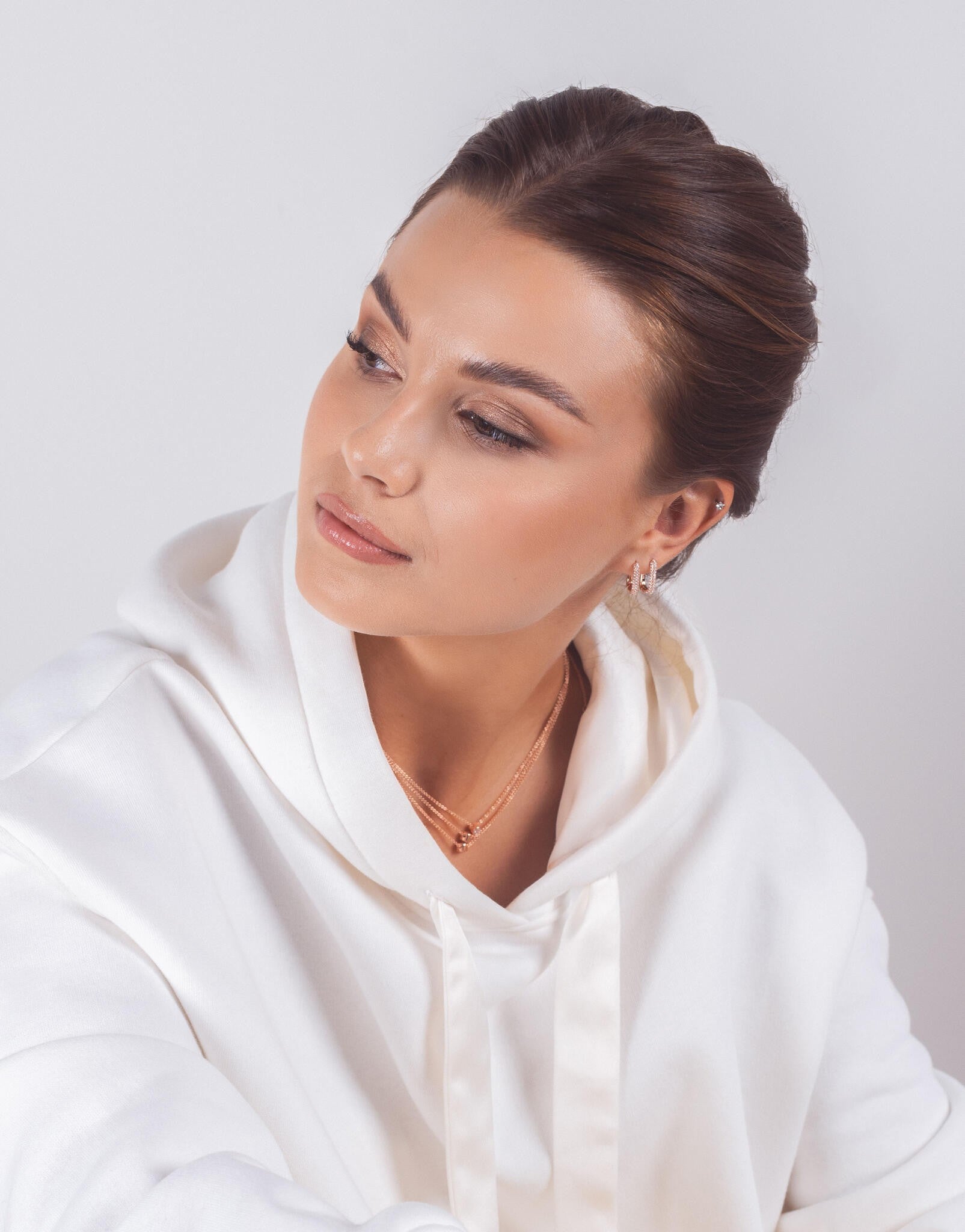 softly lit sterling silver hoop earrings with white zircons resting on a textured surface