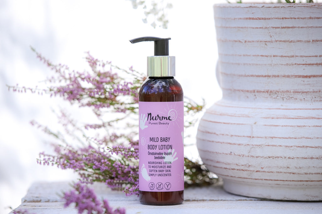 a soft-focus close-up of gentle baby lotion being gently smoothed onto a newborn's delicate skin