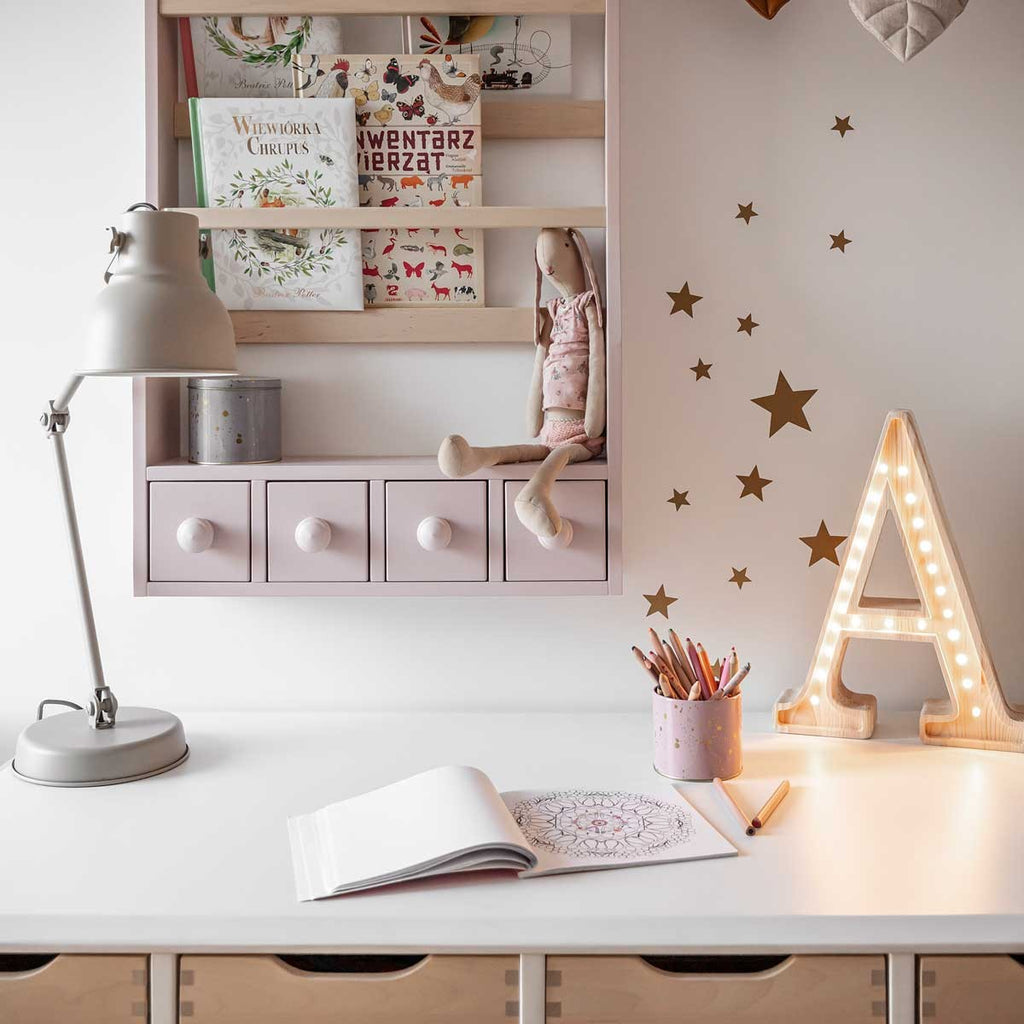close-up of a single large gold star sticker with a soft, radiant glow on a pale blue nursery wall