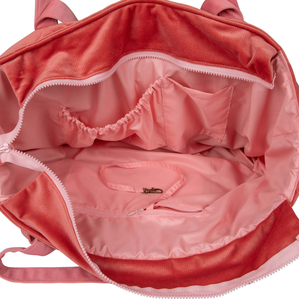 playful pink candy weekender bag held by a smiling mom in a sunlit park
