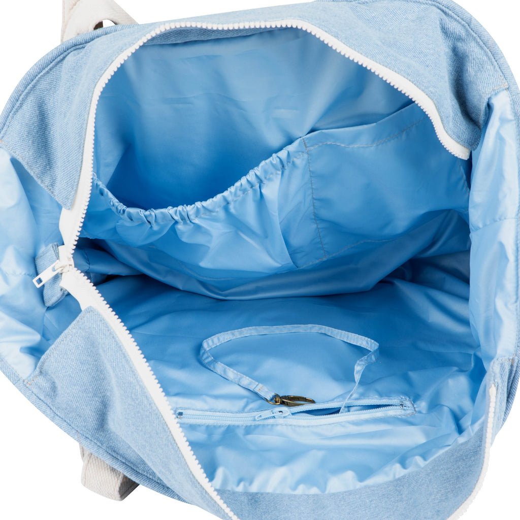 a playful denim weekender bag with a fun, patterned interior peeking out from an open zipper