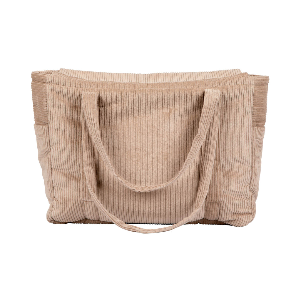 confident woman holding a chic latte-colored velvet weekender bag with multiple pockets