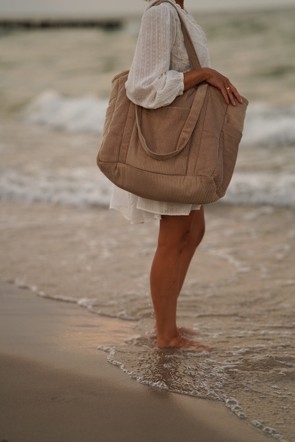 elegant latte weekender bag with velvet texture and dual shoulder straps in a refined setting