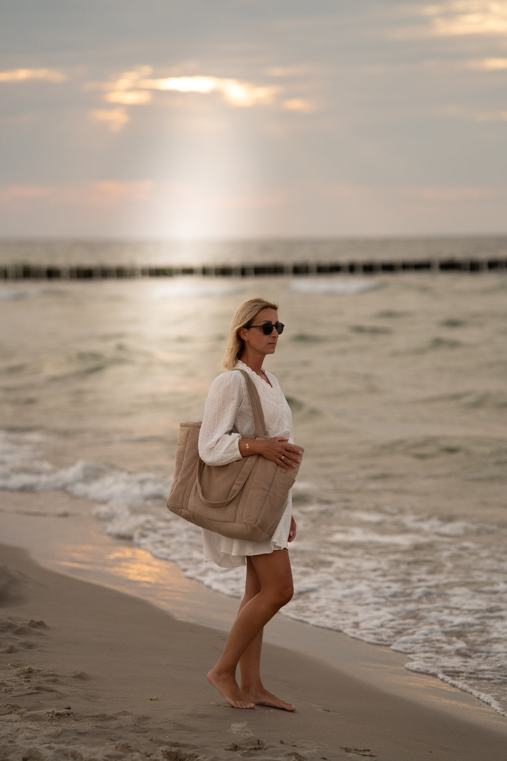 latte weekender bag with multiple pockets open on a table, showcasing its functional organization