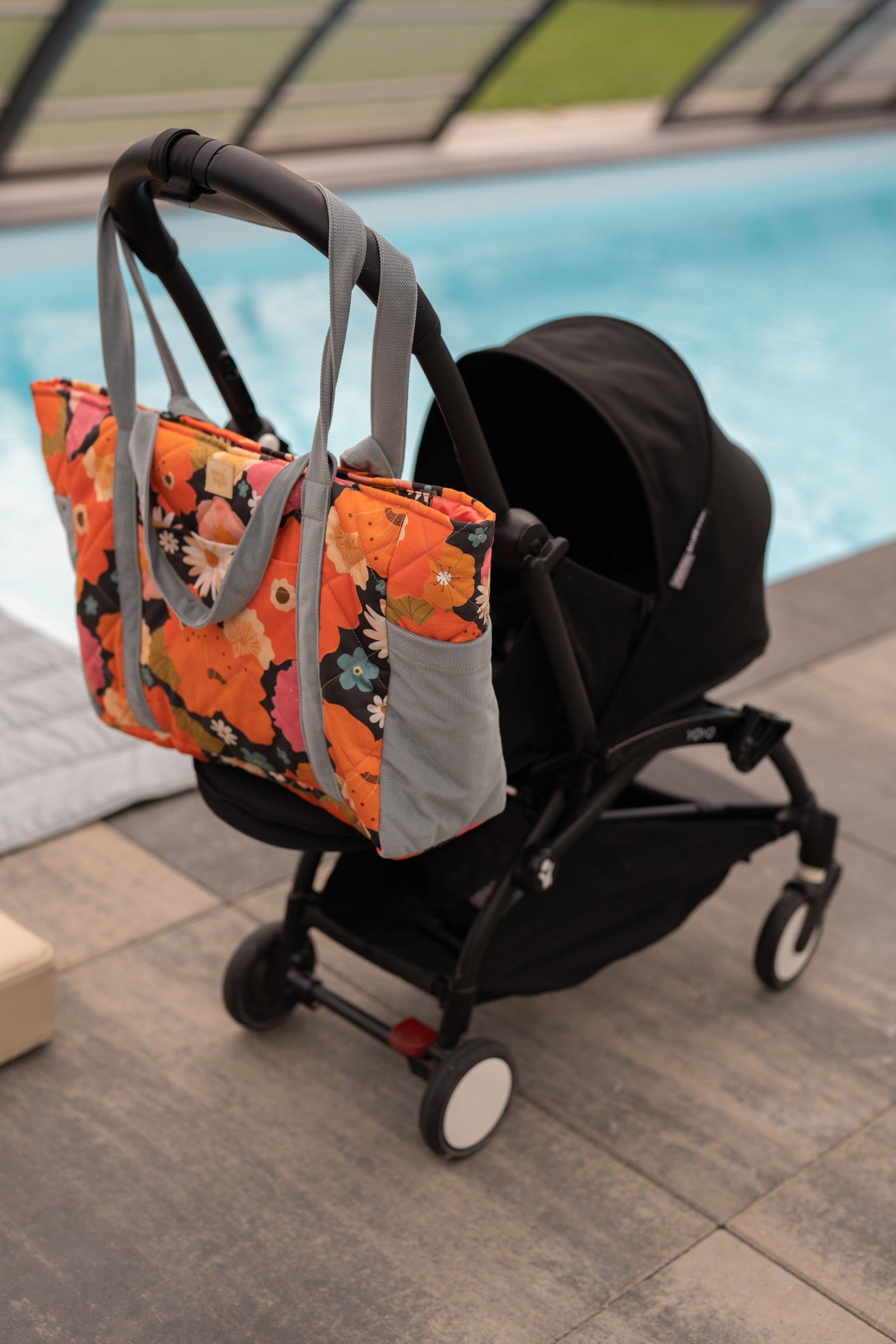 playful floral picnic weekender bag open on a sunny park bench
