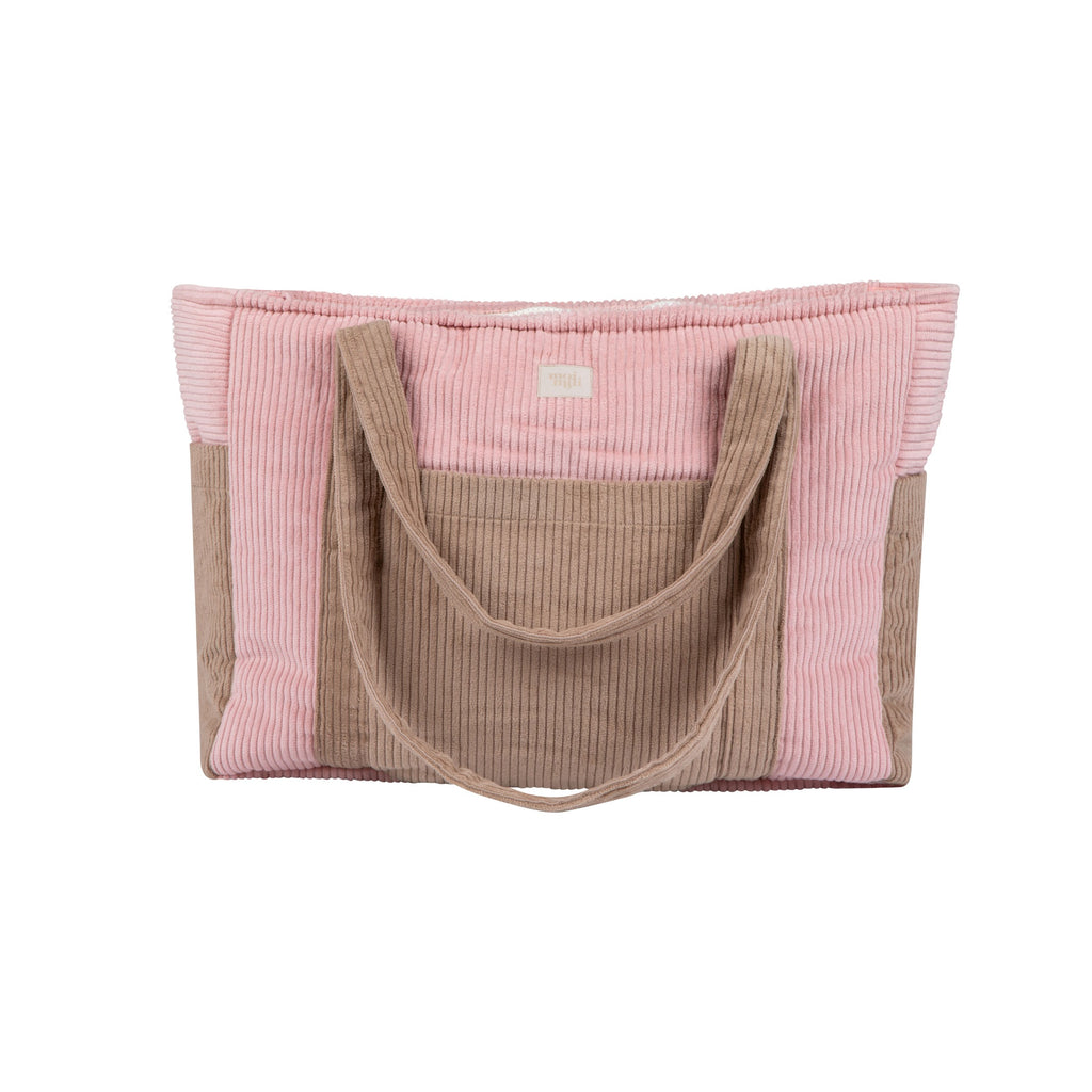 pink velvet weekender bag with dual straps and multiple pockets, shown on a wooden bench in warm morning light