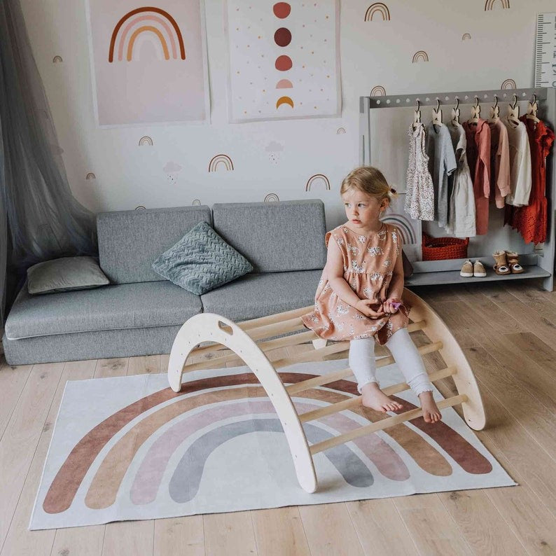 a soft-lit montessori climbing arch in a cozy nursery setting