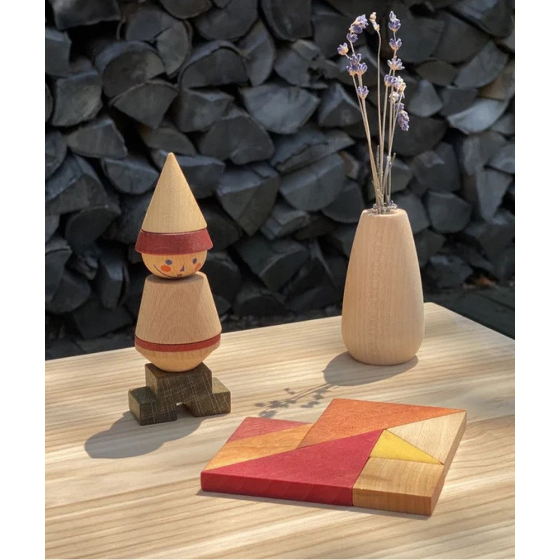 a playful dragon shape created from warm-toned wooden tangram pieces on a sunlit table
