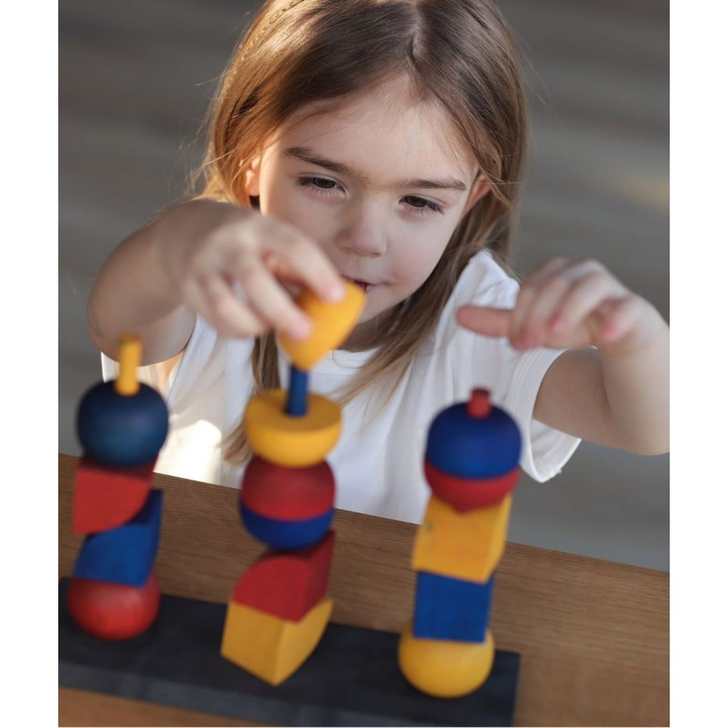 a soft-focus shot of a wooden stacking toy's geometric pieces bathed in gentle morning light
