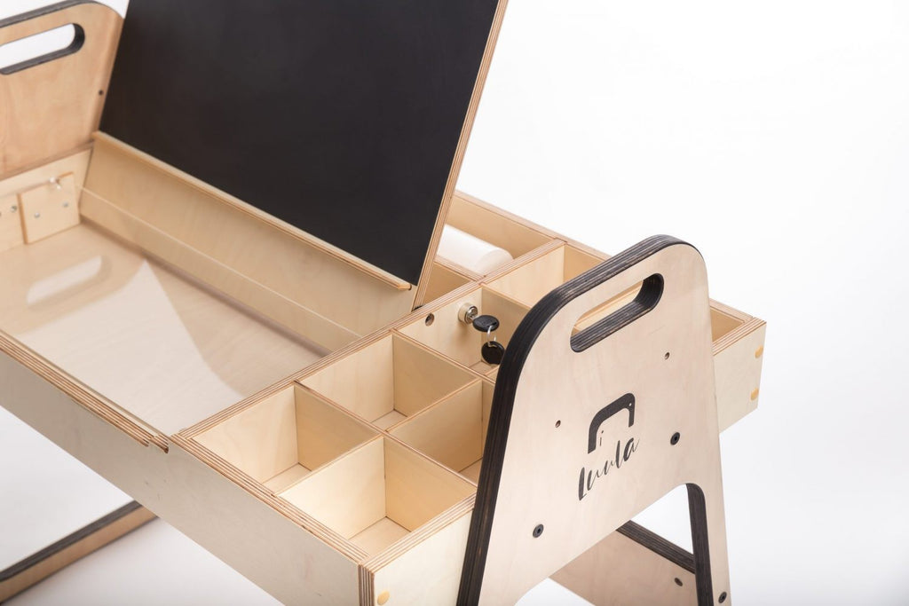 soft-lit julle kids art table with open storage boxes and a paper roll ready for creative play