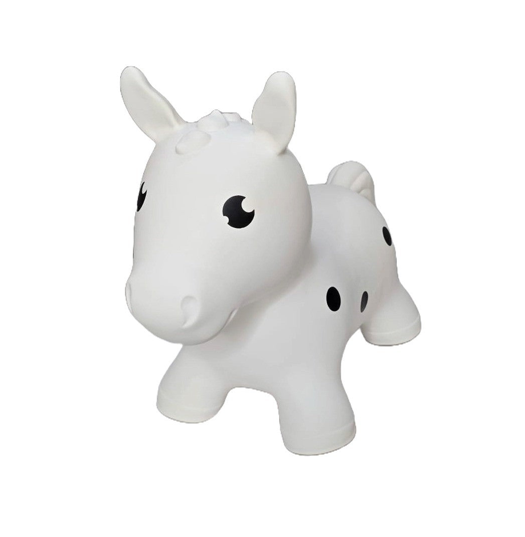 confident toddler bouncing on a white horse hopper toy indoors