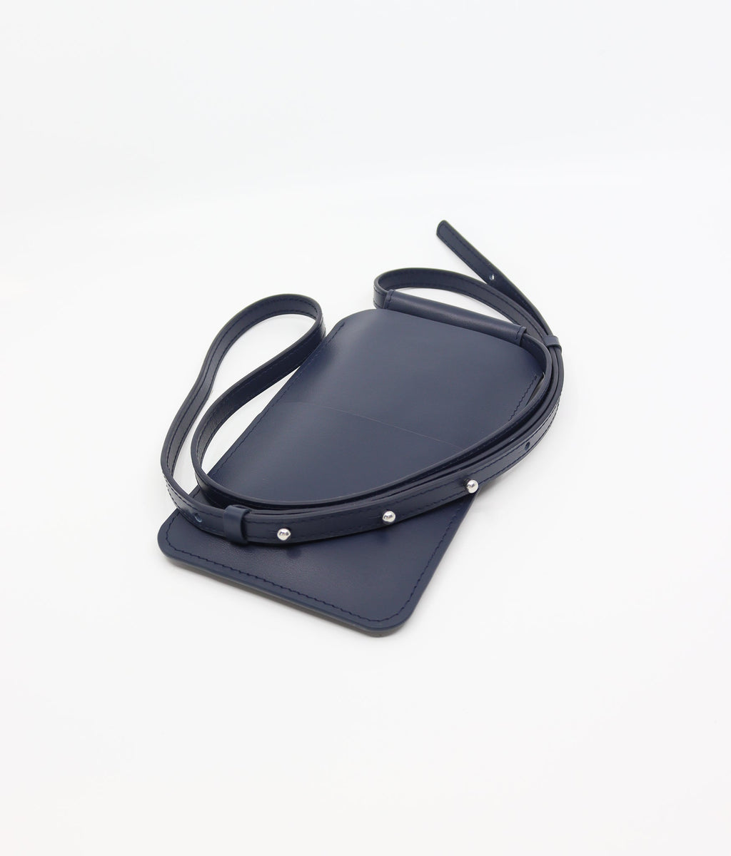 playful navy blue leather crossbody phone bag with a fun, energetic vibe on a sunny day