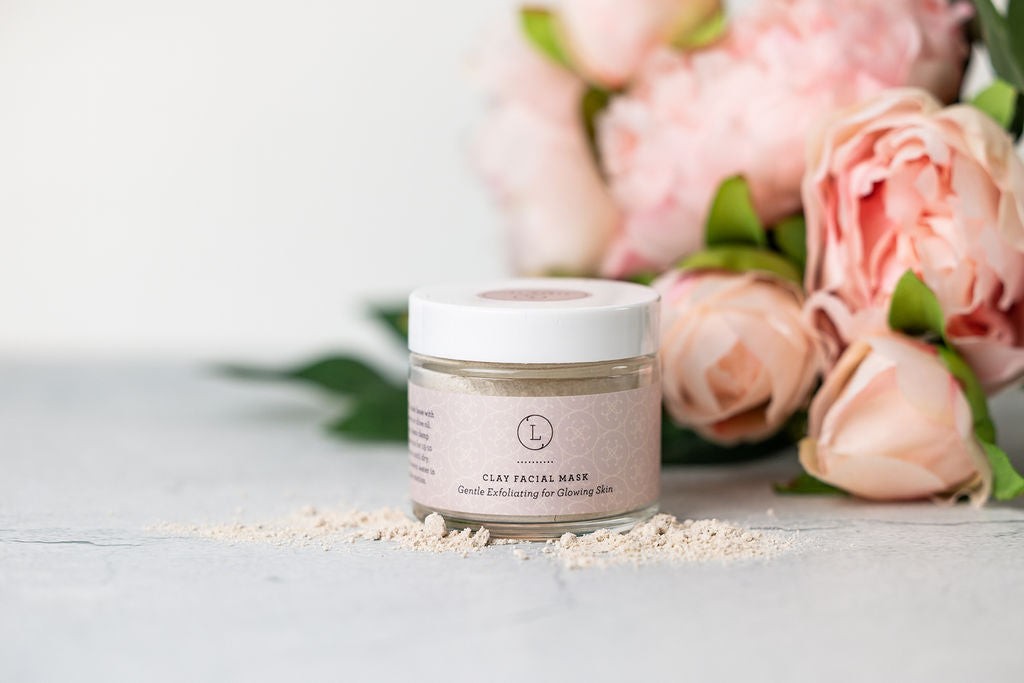 softly lit gift set for new moms with lavender soap and calming candle on a cozy textile