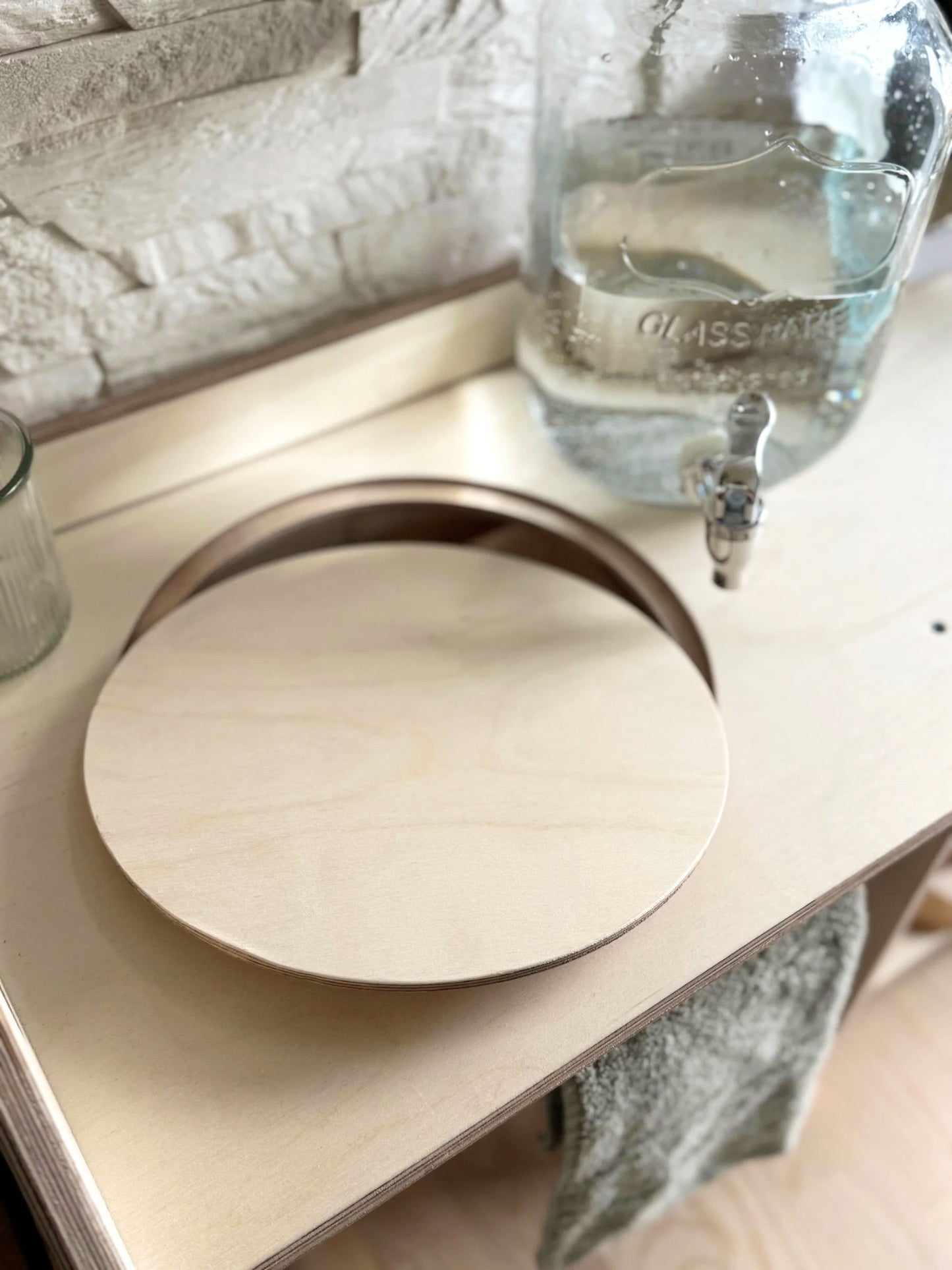 montessori wooden washbasin in a bright, sunlit room highlighting its portable design and storage shelf